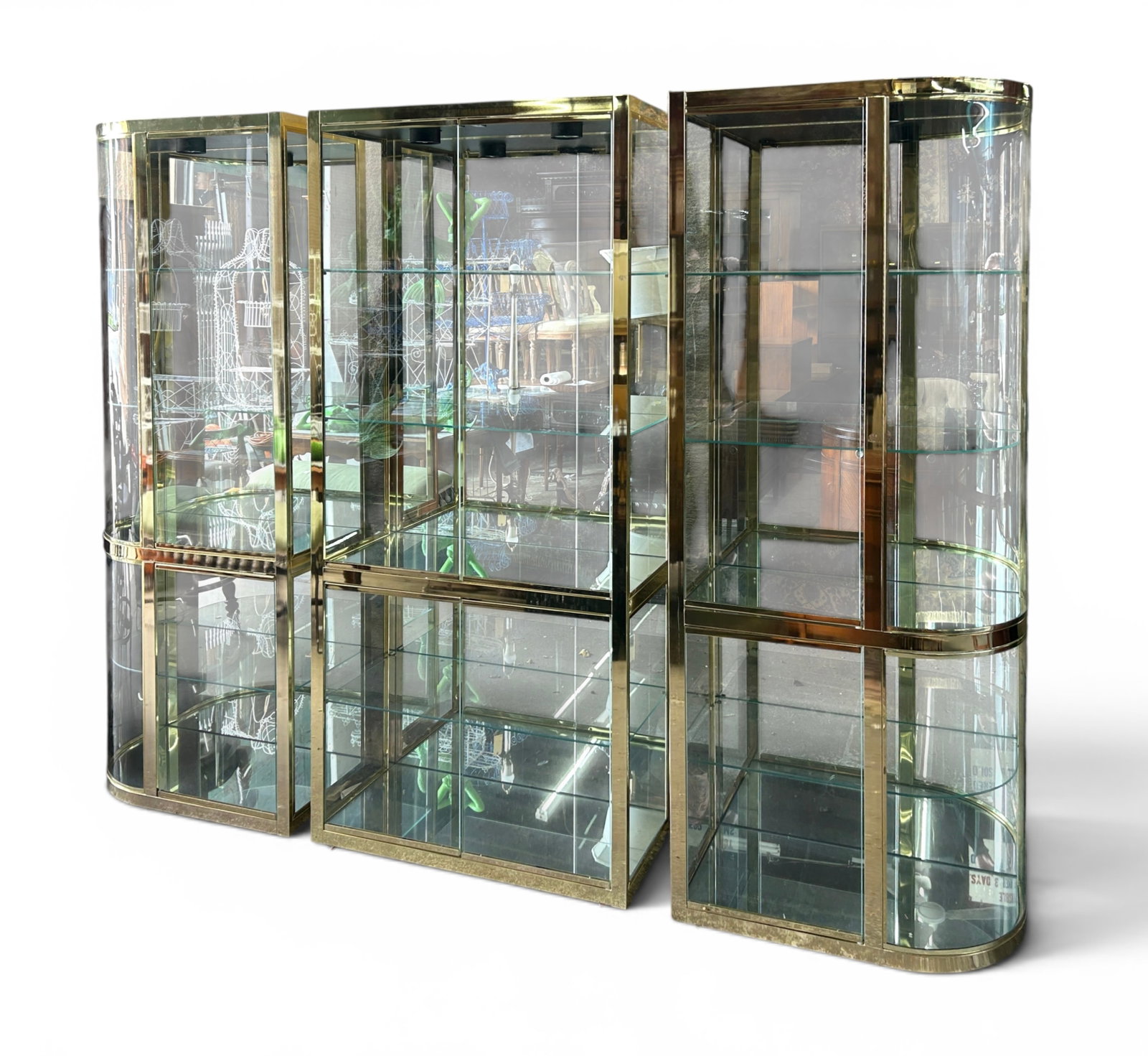 Postmodern 3-Piece Brass & Glass Display Cabinet: This postmodern Hollywood Regency style polished brass display or curio cabinet has 3 vertical pieces. Each piece has two glass shelves on the top section, one shelf on the bottom section, and mirrore