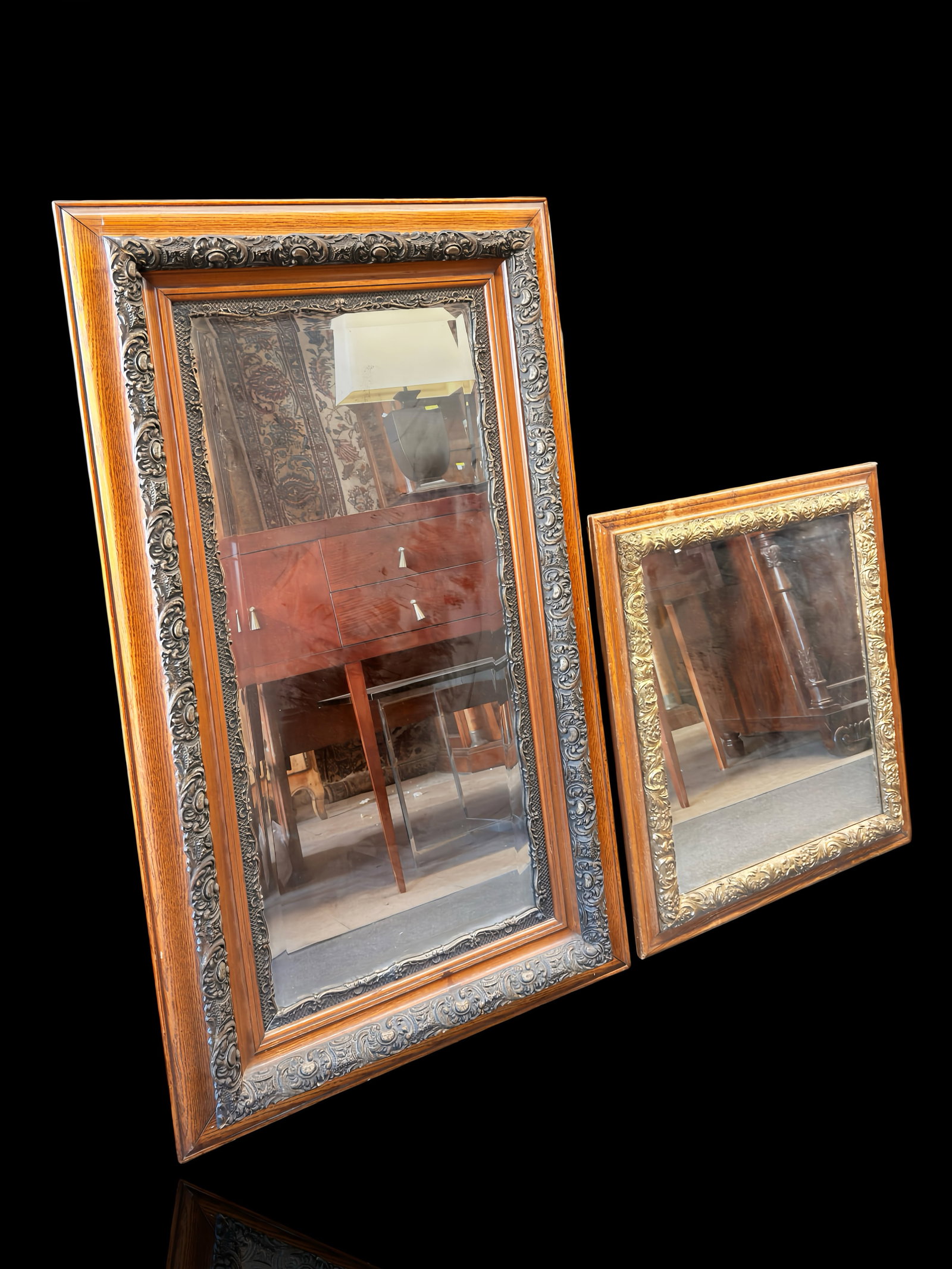 Pr. of Ornate Mirrors w/ Relief Scrolls & Flowers.: The pair of mirrors ornate frames. The smaller mirror is gilded over the relief section, and the large mirror has two ornate borders with stained wood between them, and a bevelled mirror. The smaller 