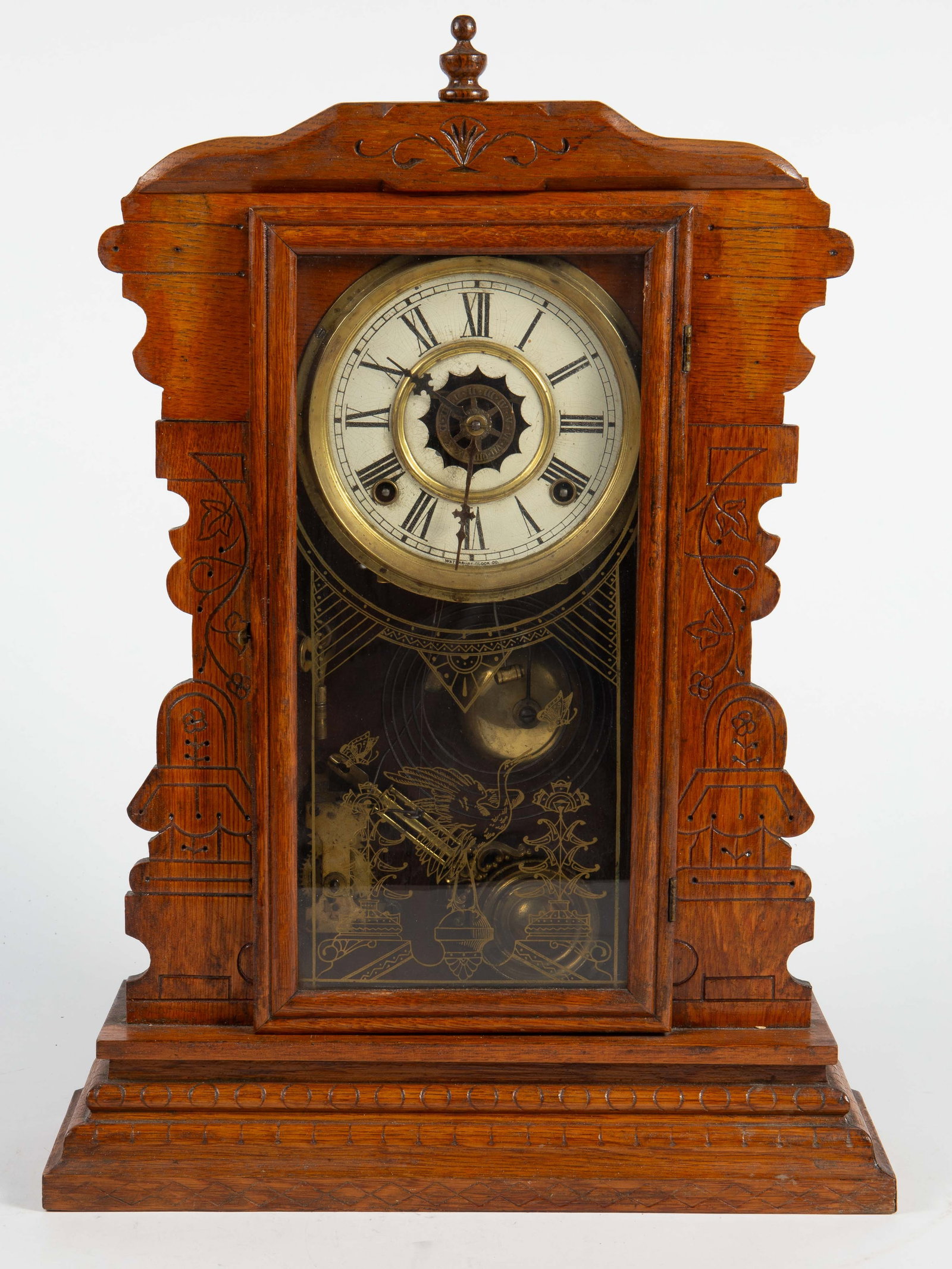 Waterbury Carved Wood Gingerbread Clock.: The working condition is unknown. The key is included. Overall, it presents well, with some signs of wear on the clock dial. The total dimensions are 15 1/8" x 4 12" x 20 5/8". In-house shipping is av