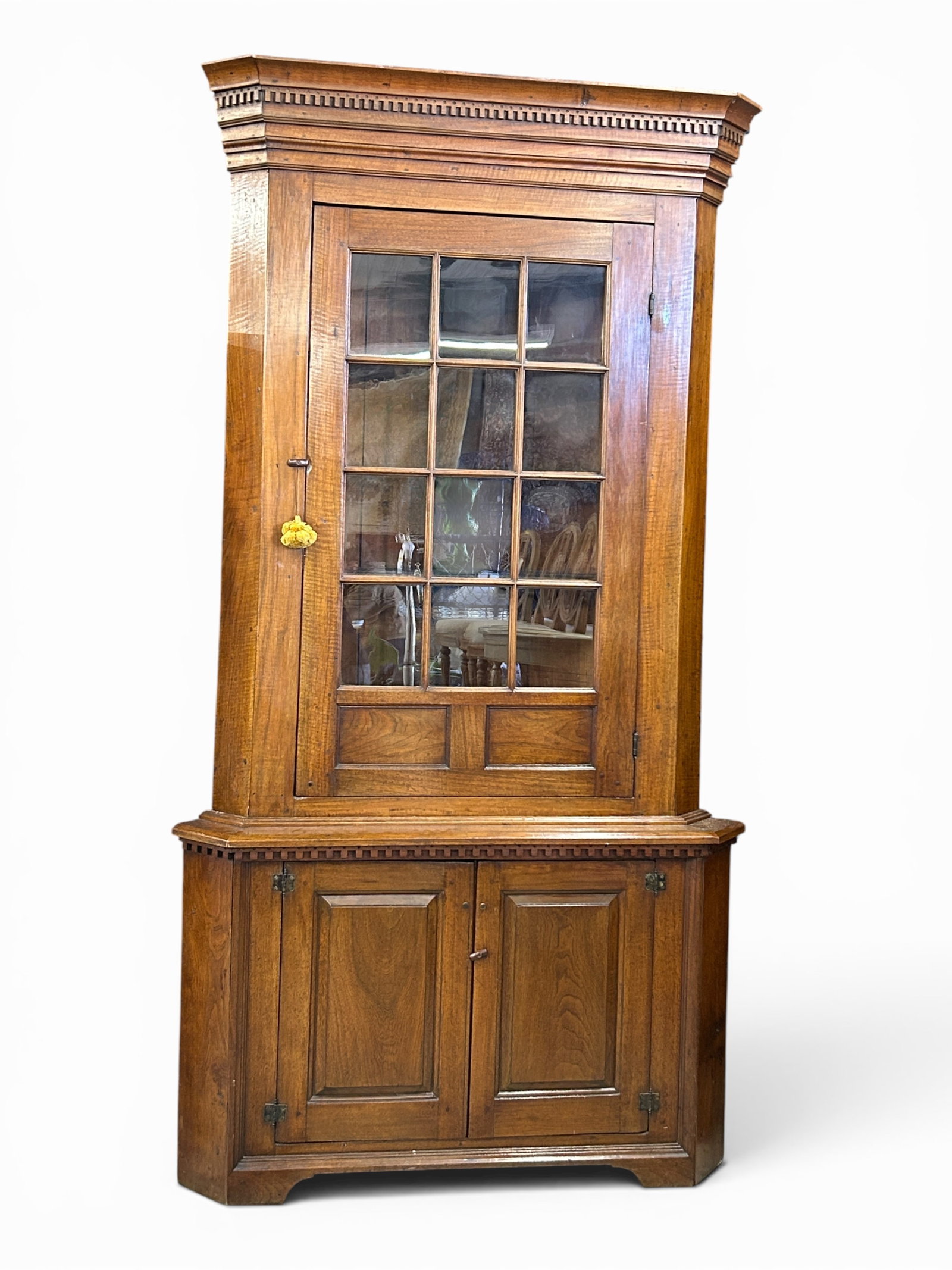 Early Cherry Wood ? Corner Cupboard Cabinet.: The wooden corner cabinet has a glass door with 3 shelves inside, and a pair of bottom doors with one shelf inside. Both the top and bottom doors close with a latch. The piece features dentil molding