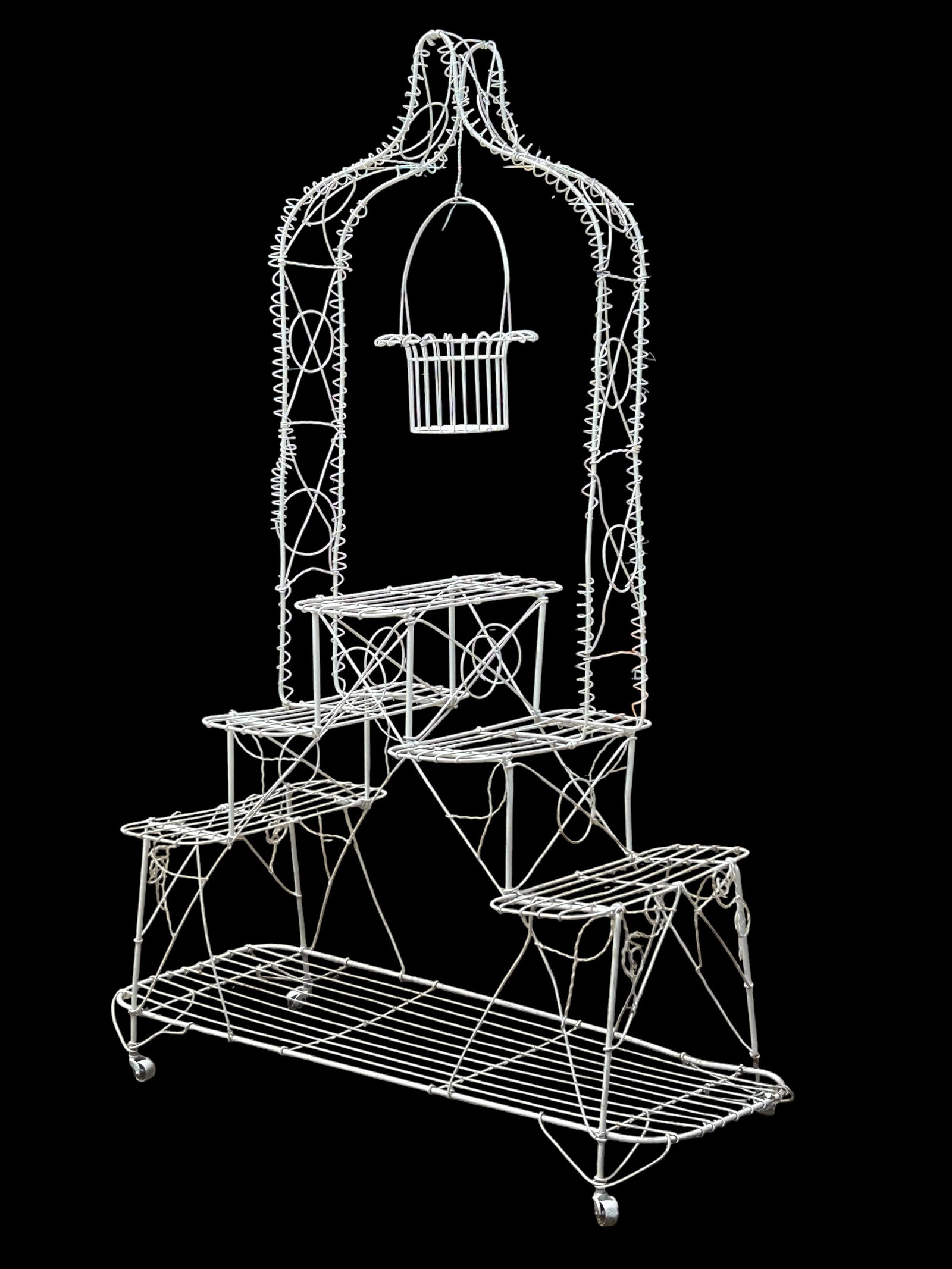 Victorian ? White Wire Plant Stand.: The large plant stand has a bottom shelf, 5 tiered small shelves, and a hanging basket. It is on casters. It measures 75 1/2" tall, 51 3/4" wide, and 22 7/8" deep. There are some scratches, stains,