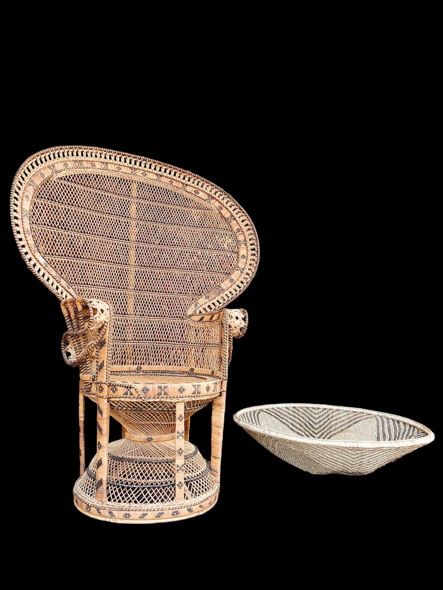 Rattan or Wicker Peacock Chair & Tonga Basket.: The lot contains 2 woven items. There is an intricate peacock arm chair with black rattan decorative patterns and elaborate arms. It measures 55 1/2" tall, 43" wide, and 22" deep. Next, there is a lar