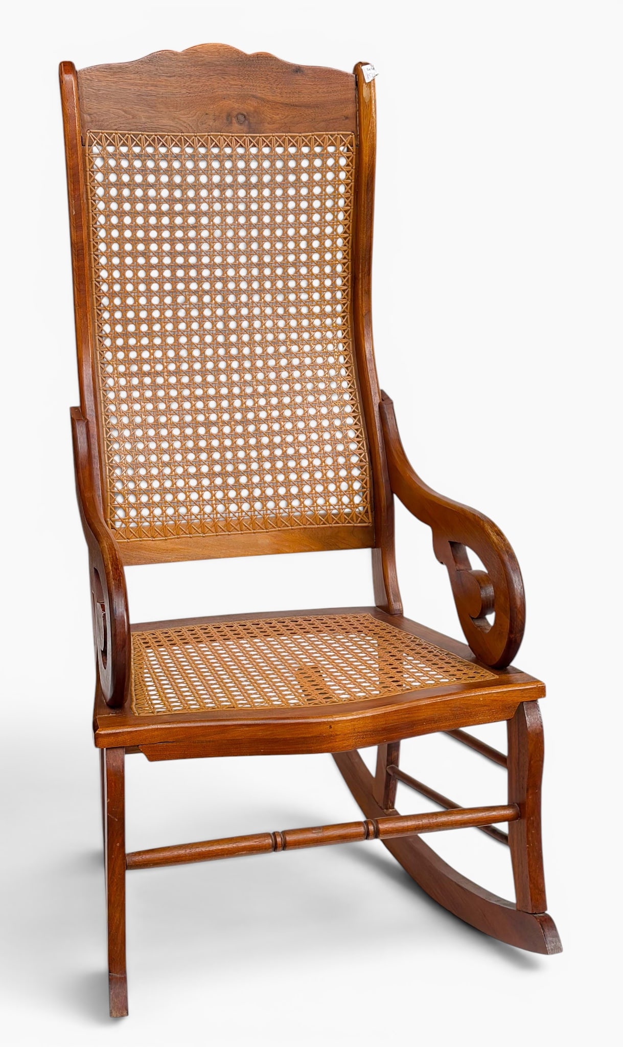 Carved Wood and Cane Rocking Chair.: The vintage rocker has curved carved arms, a turned wood stretcher, and a cane seat and back. It measures 42 1/2" tall, 22 1/2" deep, and 32" wide. There are some scratches, scuffs, and stains on the 