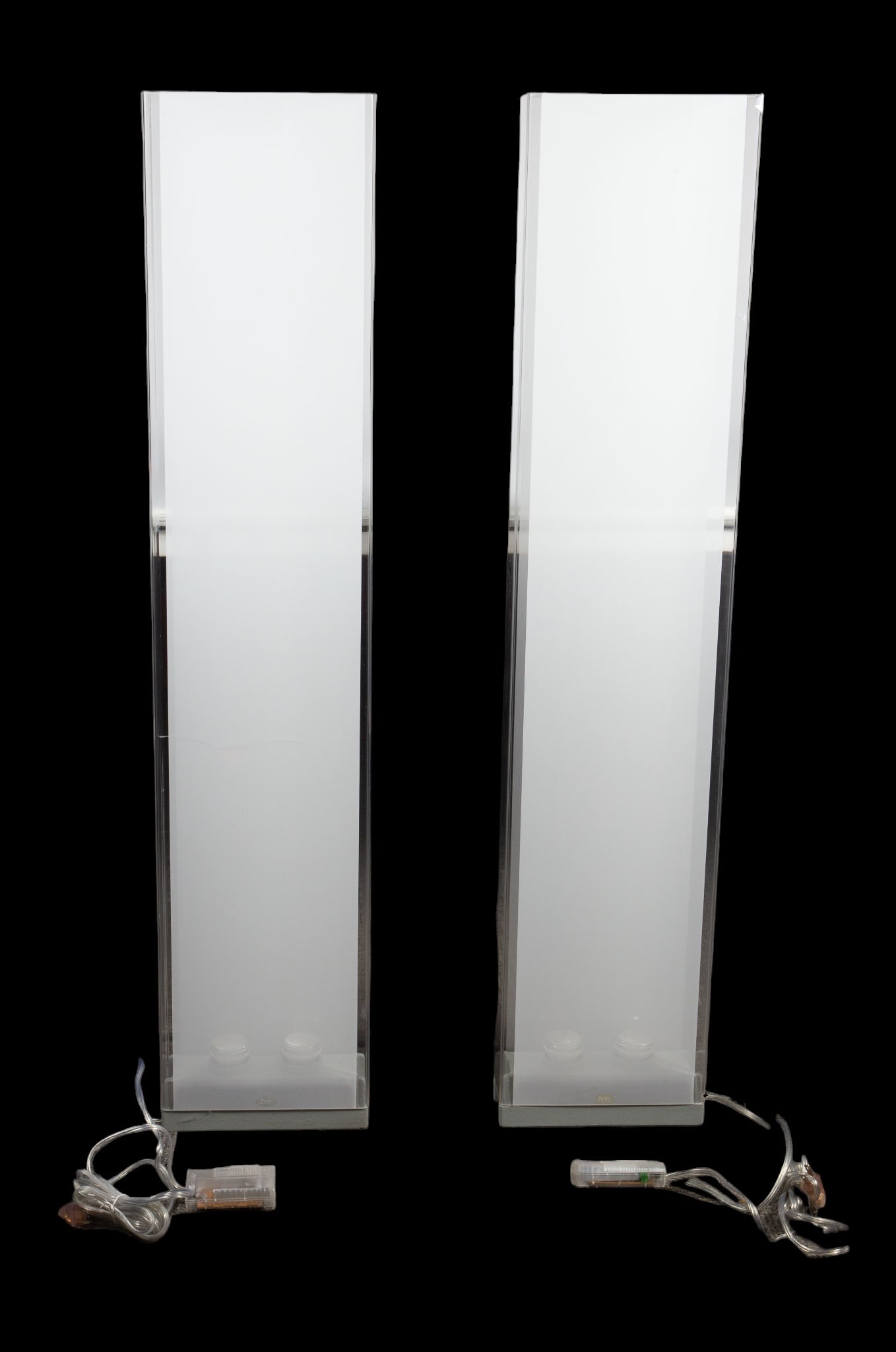 Pair of Pablo Pardo "Cortina" Lucite Floor Lamps.: The floor lamps have two lights pointing up on their heavy gray bases, with tall rectangular acrylic shades with a frosted fabric on the front top and back. One of the shades has a large crack. The cr