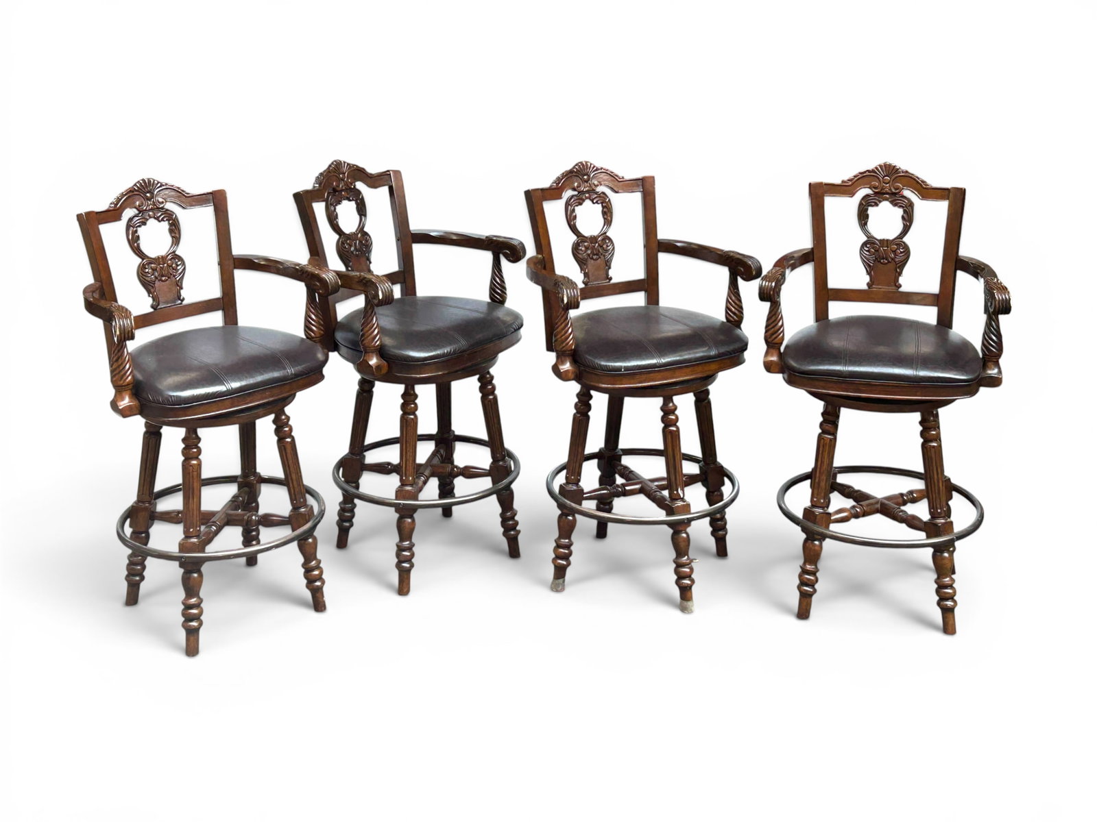 4 Carved Wood & Leather Swivel Bar Stools w/ Arms: The set of 4 bar stools feature carved wood frames with pierced backs and scroll, twist, and fan decorations. The legs are turned wood and column style and come together with an X shaped support.
