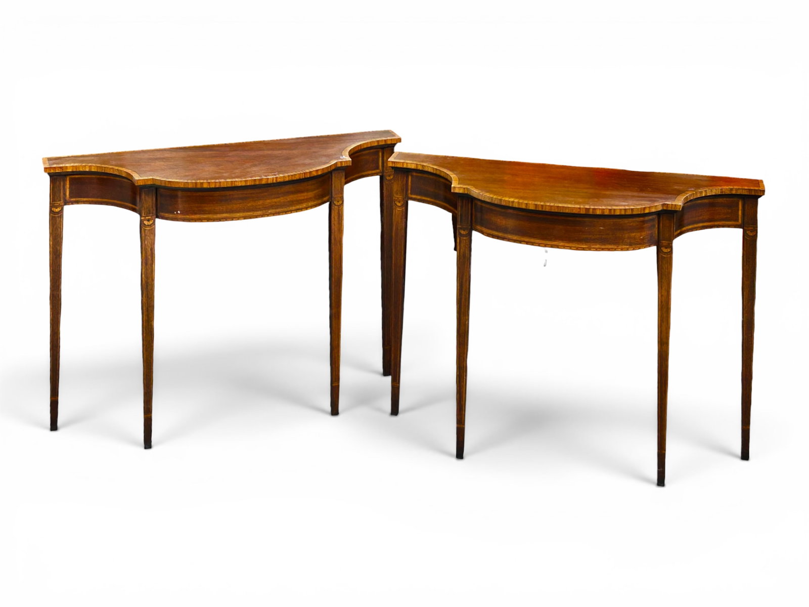 Pair of Inlaid Serpentine Front Console Tables.: The pair of tables resemble a design from Baker Furniture Historic Charleston collection. They have inlaid wood decorations at the tops of the tapered legs, as well as a satinwood border and frames. E