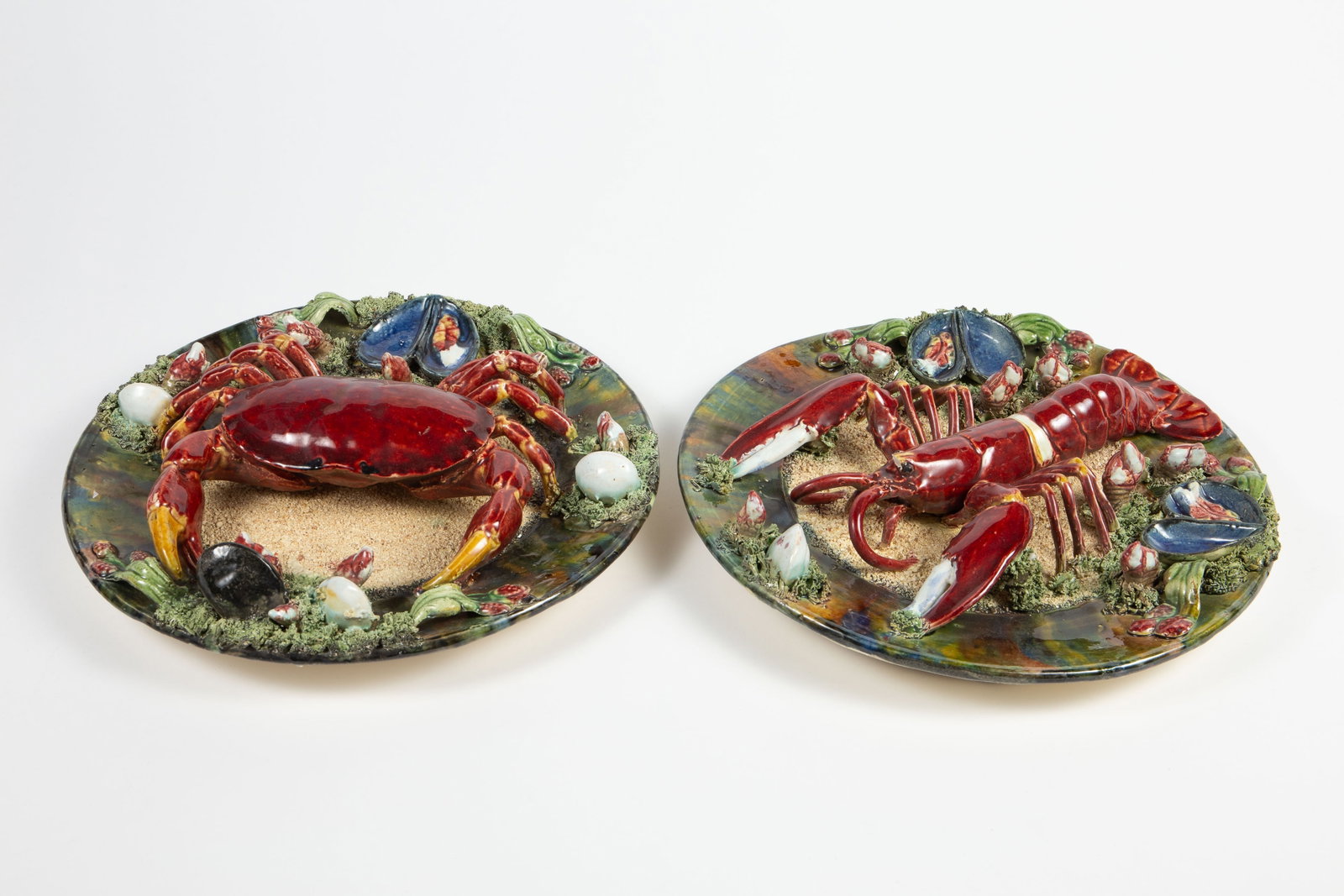 Alvaro Jose Caldas Da Rainha Majolica Plaques.: These pottery plates have crustacean themes- one is a lobster, the other is a crab. Overall, they look to be in good cosmetic condition. They each measure approximately 12 1/4" x 12 1/4" x 2 1/2".