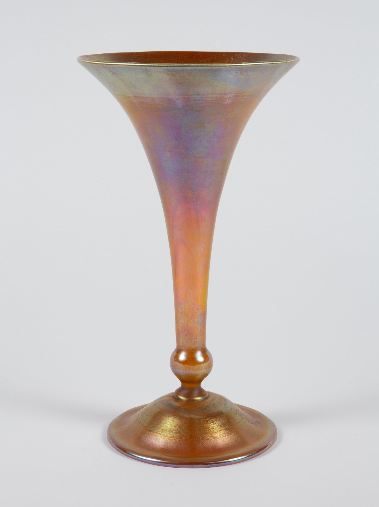 L.C.Tiffany Favrille Aurene Glass Trumpet Vase.: The gold Aurene glass iridescent vase by Louis Comfort Tiffany is etched L.C. Tiffany - Favrille on the underside. It measures 11 1/8" tall, and up to 6 3/16" in diameter. There are some scratches
