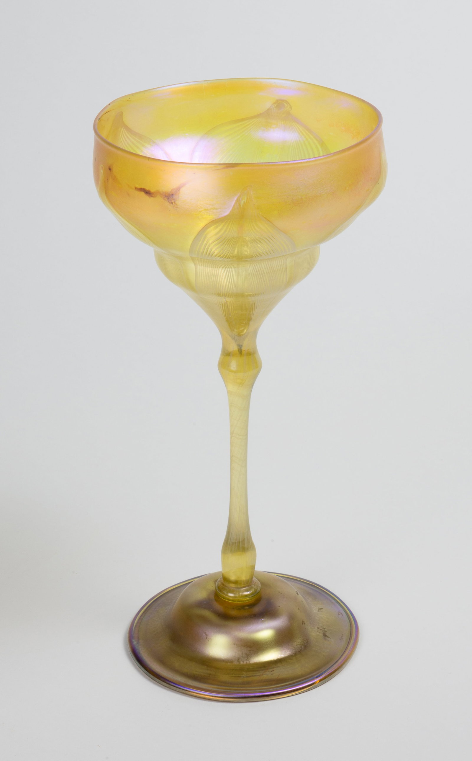 Tiffany Studios Pulled Feather Floriform Vase.: The yellow iridescent stemmed vase has the "Tiffany Favrille Glass Registered Trademark" sticker on the underside, along with the number 07945. It measures 9 7/8" tall and up to 5" in diameter. There