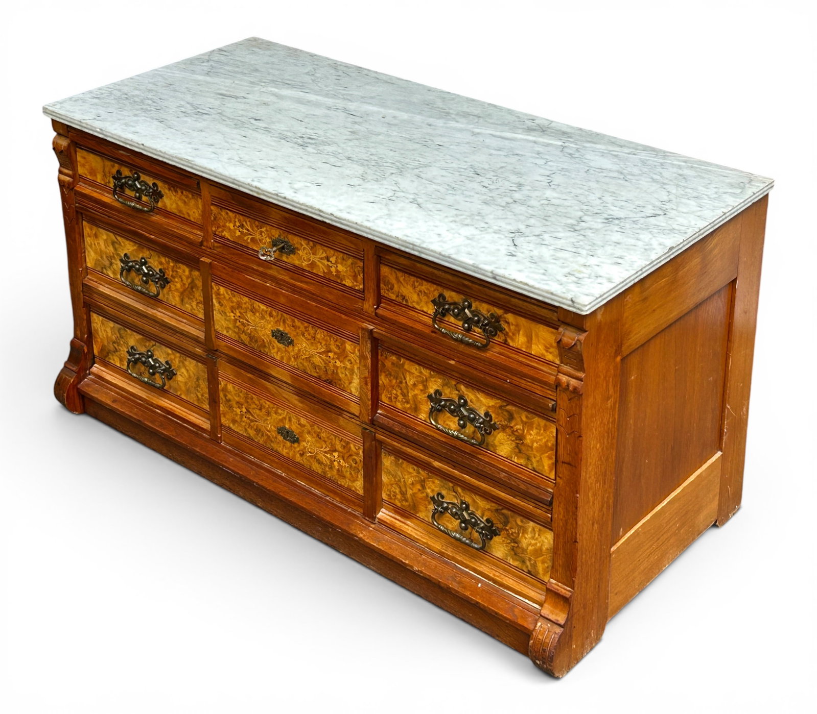 Victorian Marble Top Dresser with Marquetry.: This antique burled walnut wood dresser or sideboard has fine inlay, a white marble top, three small drawers, and two large lower drawers. It has ornate brass handles and decorative keyholes. A key