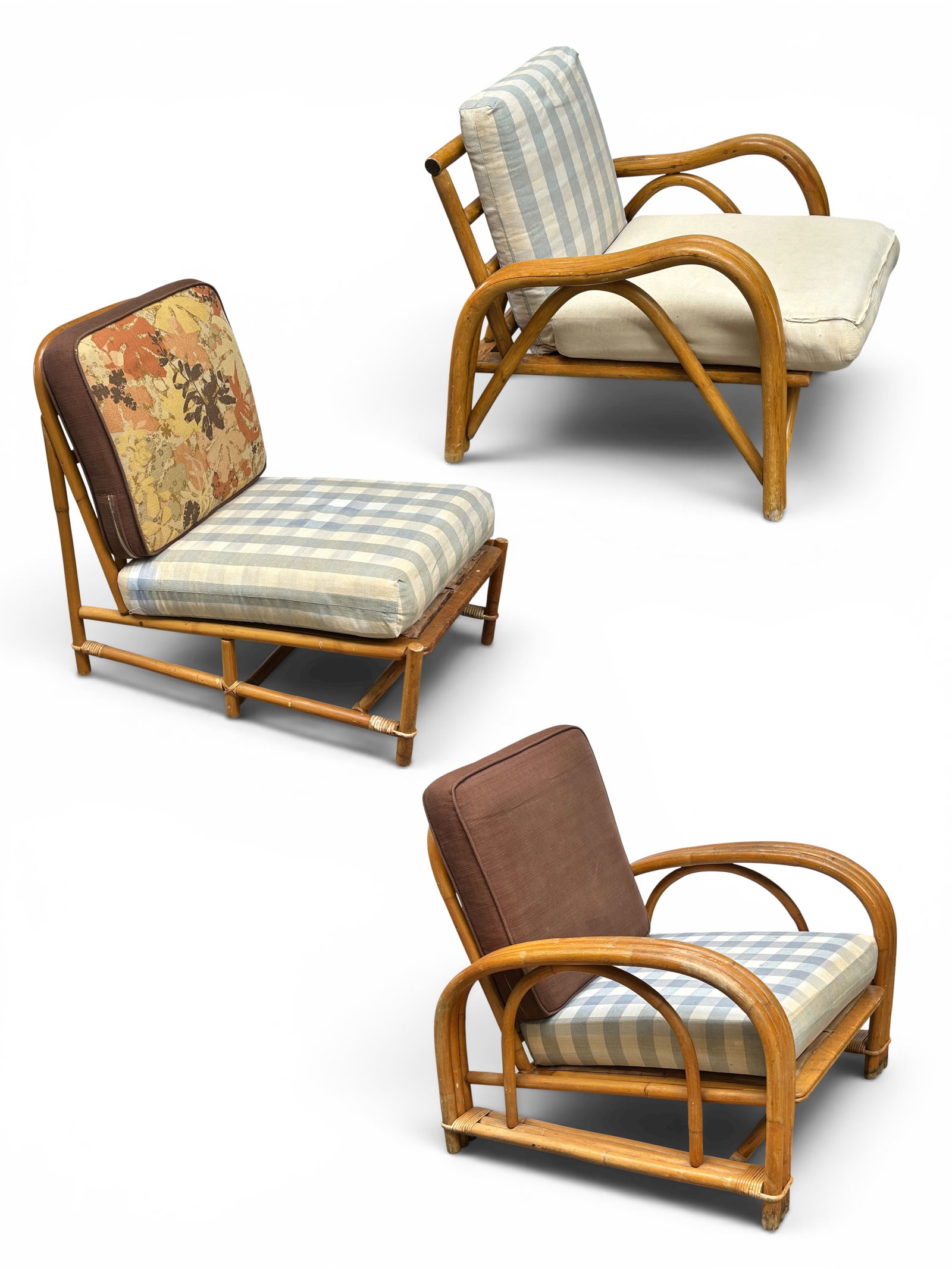 Set of Three Ficks Reed Rattan Lounge Chairs.: Two of the chairs have arms, while one is armless. The cushions need to be reupholstered. There are some scratches, scuff marks, and indentations. Overall, they are in good condition, and