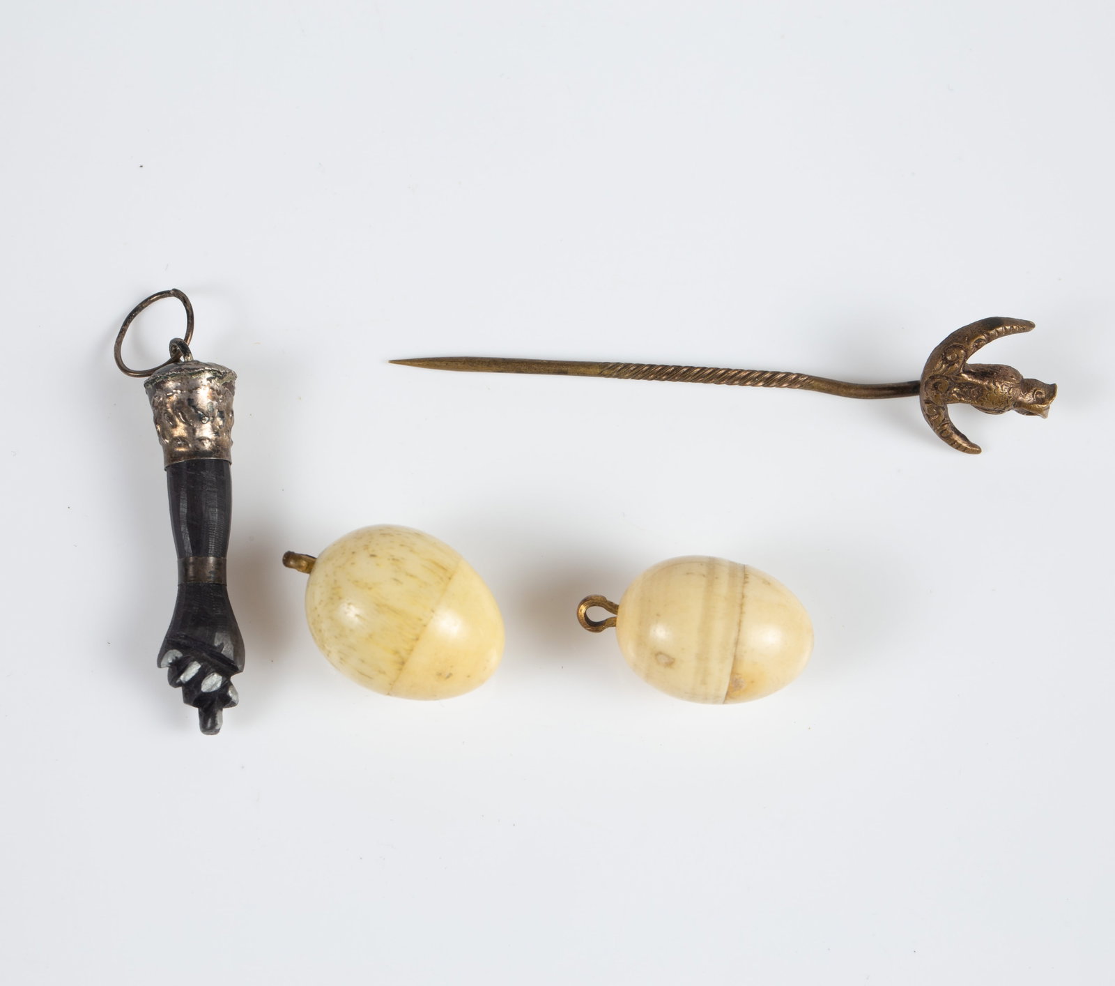 Lot of Antique Jewelry - Victorian Eggs, Figa Hand: The lot contains 4 items. There are 2 tiny carved bone egg pendants with tiny carved chick figures inside them, a Figa hand pendant with a silver setting, and an owl and crescent moon stickpin. The