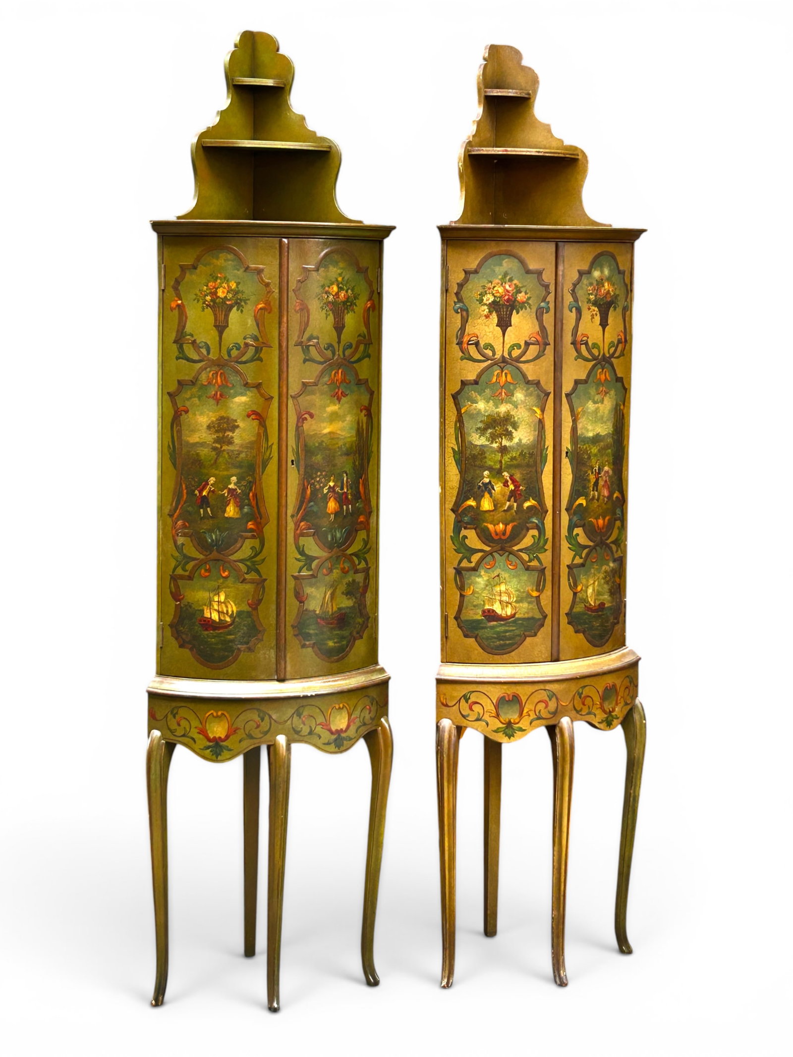 Pair of Tall French Hand Painted Corner Cabinets.: The pair of French handpainted cabinets have 4 legs, 2 doors with 2 shelves inside, and a gallery top with 2 shelves. The cabinets have matching painted scenes on the doors and apron, which include co