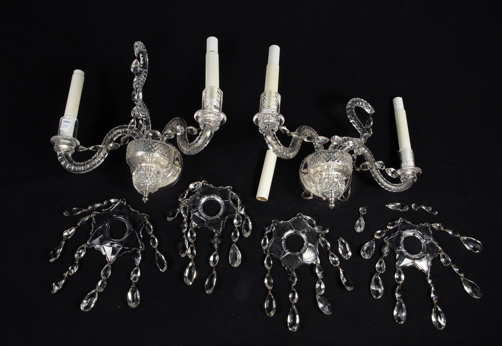 Pair of Crystal Candelabra Wall Sconces.: They look to be in the style of Waterford. Each sconce has numerous teardrop crystal prisms and serpentine arms. One of the snakelike structures has a chip; overall, the lot looks to be in good condit