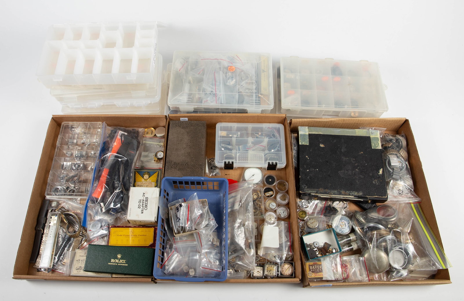 Lot of Watch Repair Parts - Dials, Bands, Etc.: The lot contains a large assortment of watch parts, 3 vintage aspirin tins, a Seiko AC Adapter TD02, a loose pearl, some plastic organizer boxes, and more. Some of the brands observed on the dials are