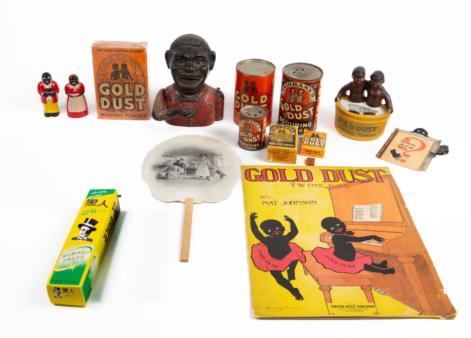 Lot of Fairbanks Gold Dust, Other Black Americana.: This lot includes cans of Gold Dust scouring powder, boxes of Gold Dust washing powder (including one hat is sealed), a Gold Dust twins sponge holder, a cast iron coin bank with moving eyes, a tube of