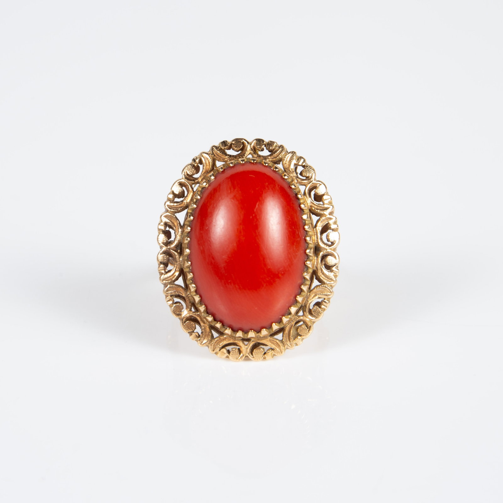 18K Yellow Gold Ring W/ Coral Cabochon.: The ring is marked K18 inside the band. It features a large red coral oval cabochon stone in an ornate setting. The stone measures 20mm x 15mm, and the gold setting around it measures 27mm x 22mm. The