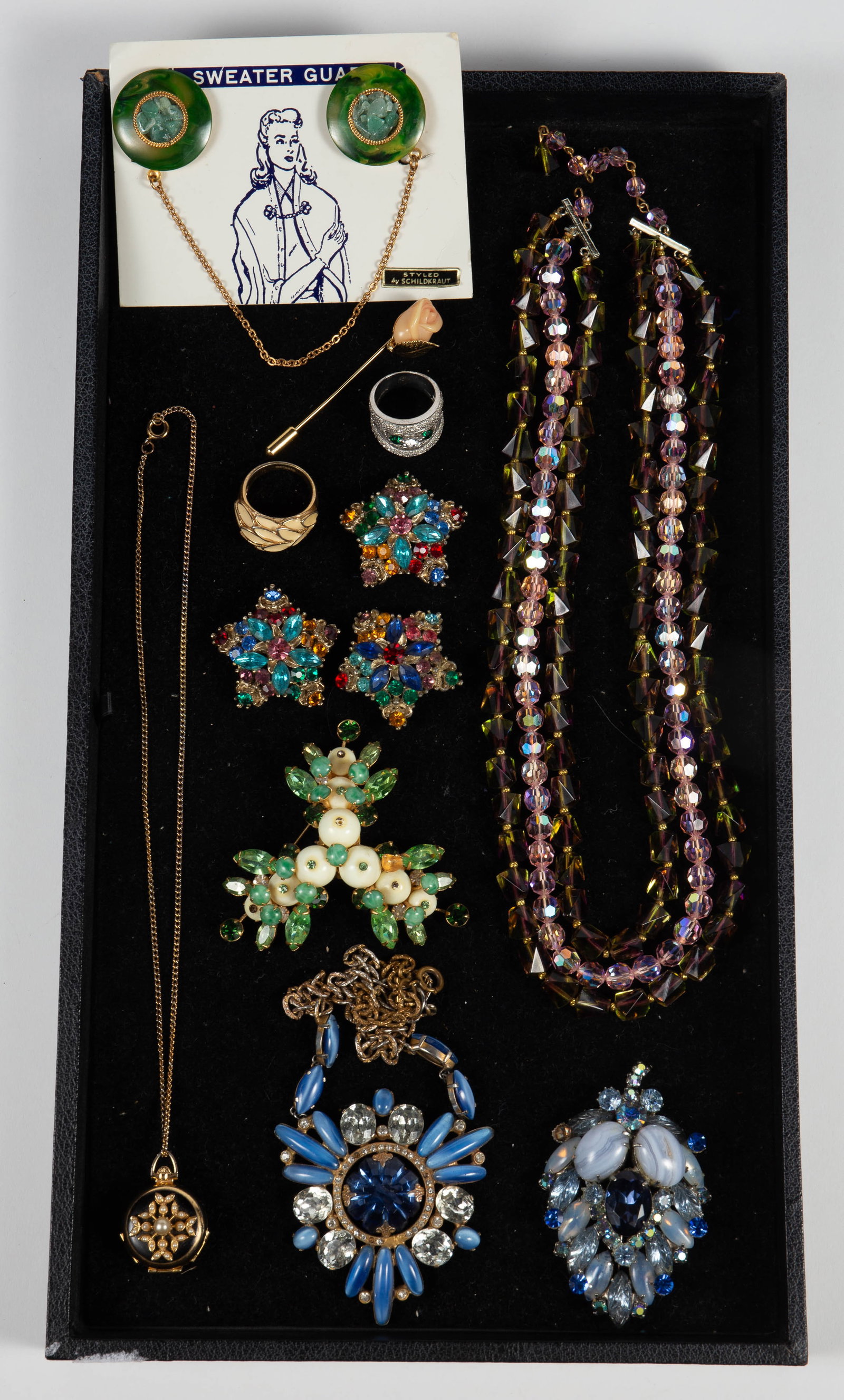 Jewelry inc Carnegie Brooch, Isser Singer Necklace: The lot contains 12 pieces of fine vintage costume jewelry. There is a blue rhinestone necklace by Isser Singer & Son New York, a green rhinestone brooch by Hattie Carnegie (missing a few stones), and