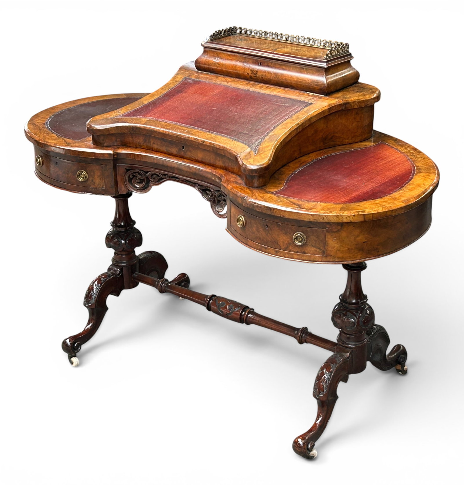 Antique Carved Victorian Ladies Writing Desk.: This burled walnut kidney-shaped desk features a three-section leather top, a raised center with a lift top, interior storage, and two drawers. It has a gallery top that lifts up, with interior