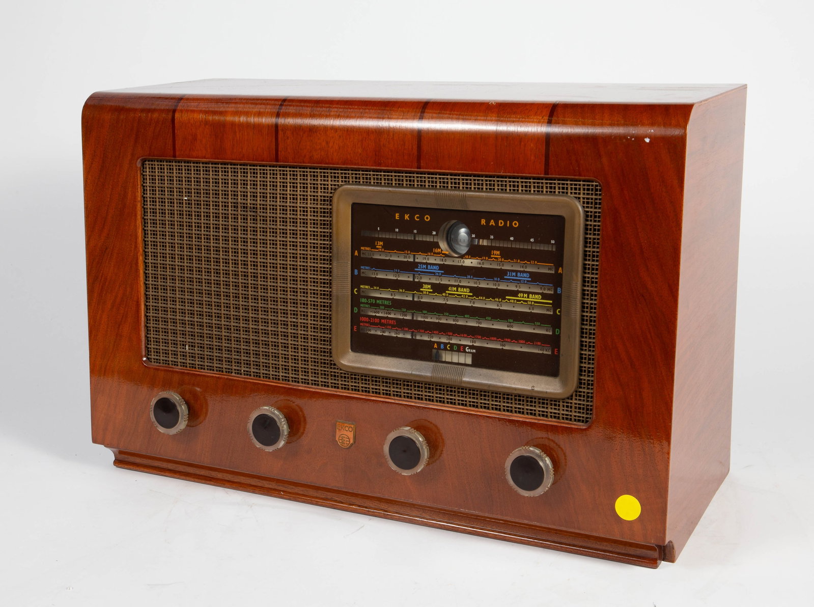 Ekco Mid Century Radio Receiver Model A137.: The vintage radio was manufactured in England circa 1955. It has a walnut veneer with inlaid dark wood stripes at the top. It has the power cord. It is untested. It measures 13 1/2" tall, 20 3/4"