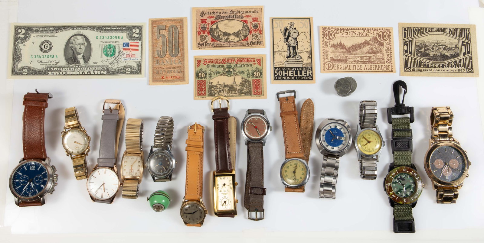 Lot: Vintage Watches & More - Military, G.F., Etc.: The lot contains 14 vintage watches, a small group of steel pennies, a $2 bill from 1976 with a stamp, and a small group of foreign currency. The watches are an enameled call pendant watch, an Elgin 1