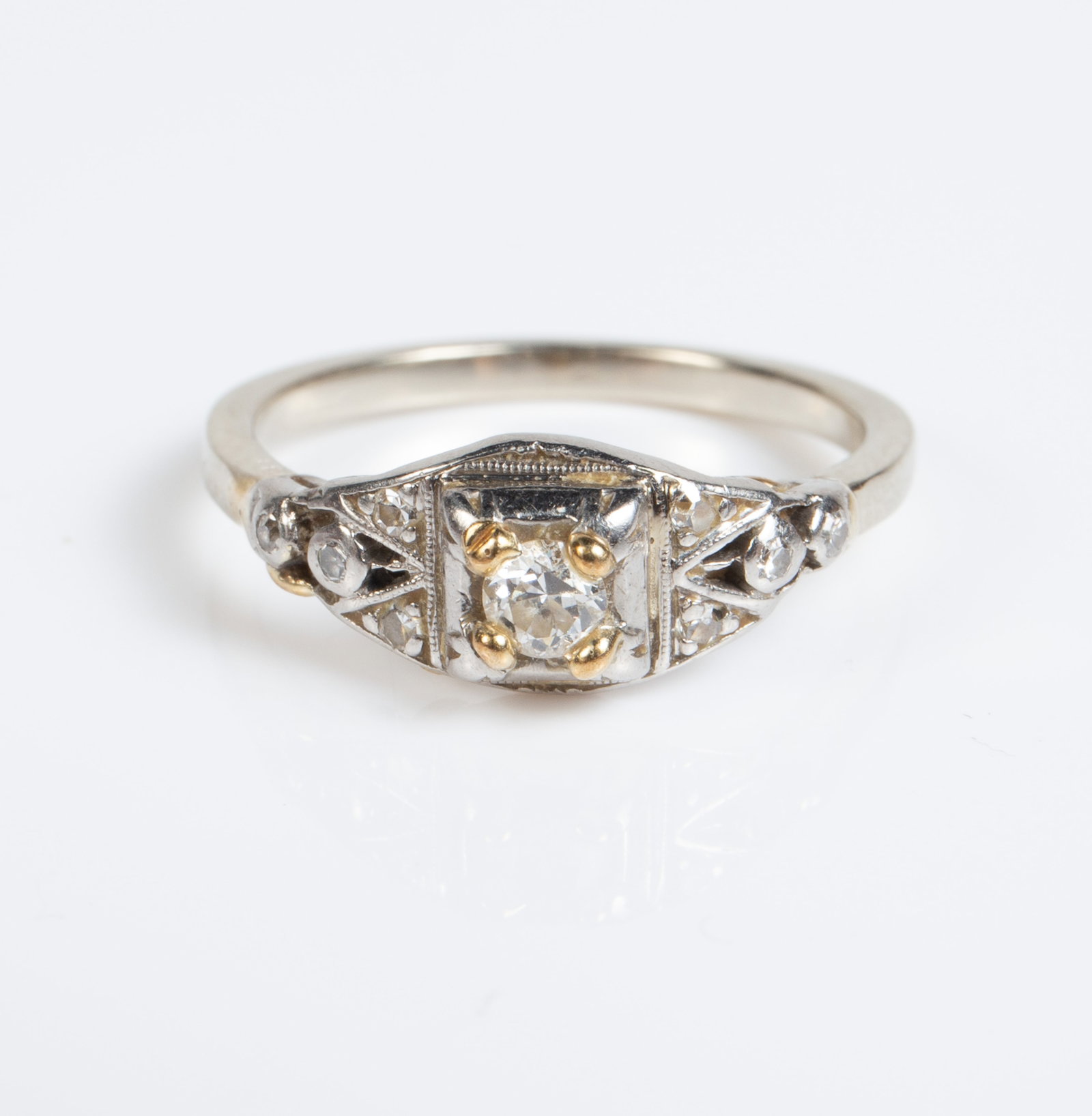 Art Deco 14K Mostly White Gold & Diamond Ring.: The ring is unmarked, but tested appropriately for 14K gold. It has a central round diamond held by yellow gold prongs. The central diamond measures 3mm in diameter. There are 3 small round diamonds o