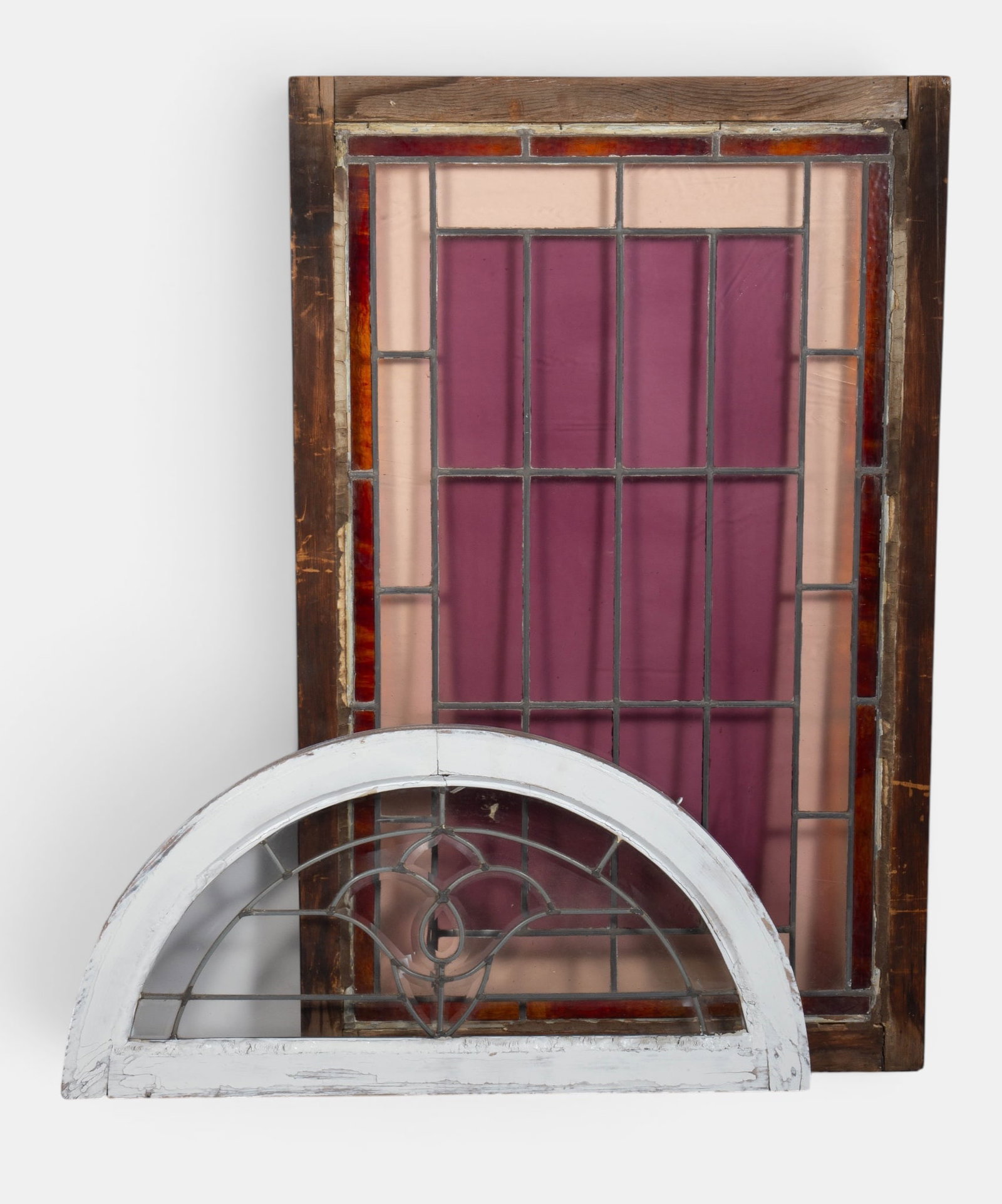 Lot of 2 Leaded Glass Windows.: The lot consists of a semi-circle transom window and a rectangular window with amber colored and pink panels. The smaller window measures 32 7/8" x 16 3/8" x 1 3/8". The larger window measures 27 7/8"