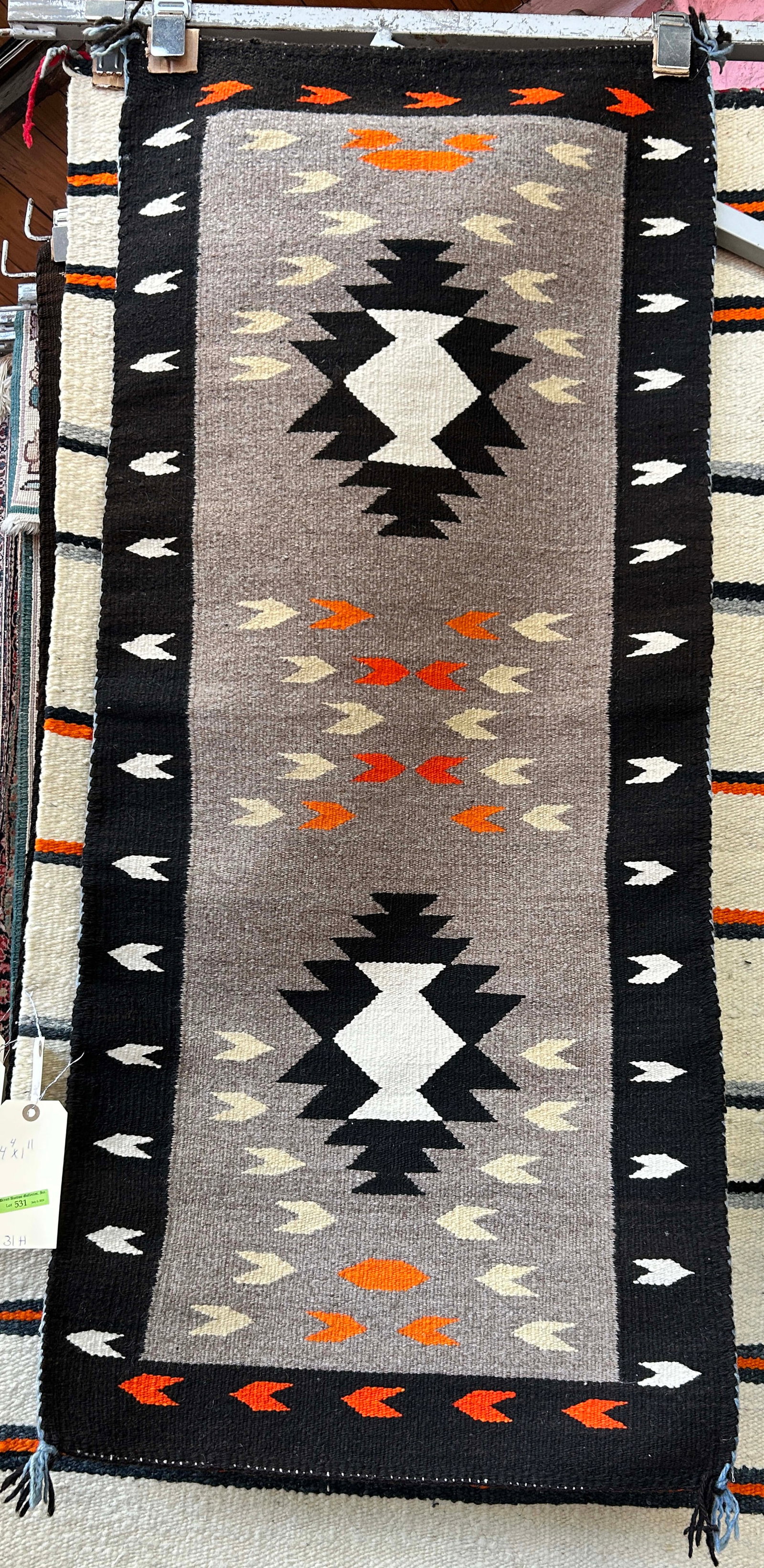 1' 11" x 4' 4" Brown Field Navajo Rug.: The rug looks to be on the newer side. It looks to be in good overall condition. In-House Shipping is available for this rug. Please see our website for our in-house shipping procedures.