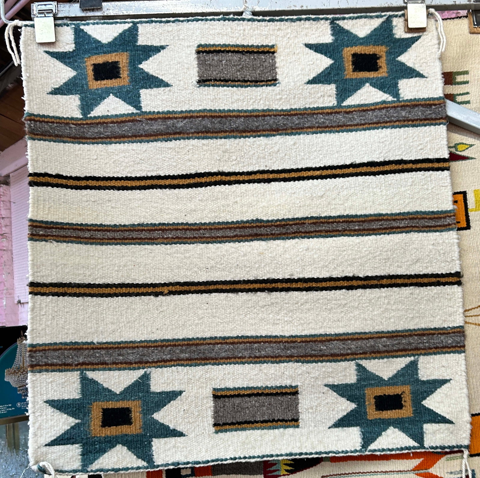 2' 4" x 2' 5" Beige Navajo Rug.: The rug has star and stripe designs. It looks to be on the newer side. It looks to be in good overall condition. In-House Shipping is available for this rug. Please see our website for our in-house sh