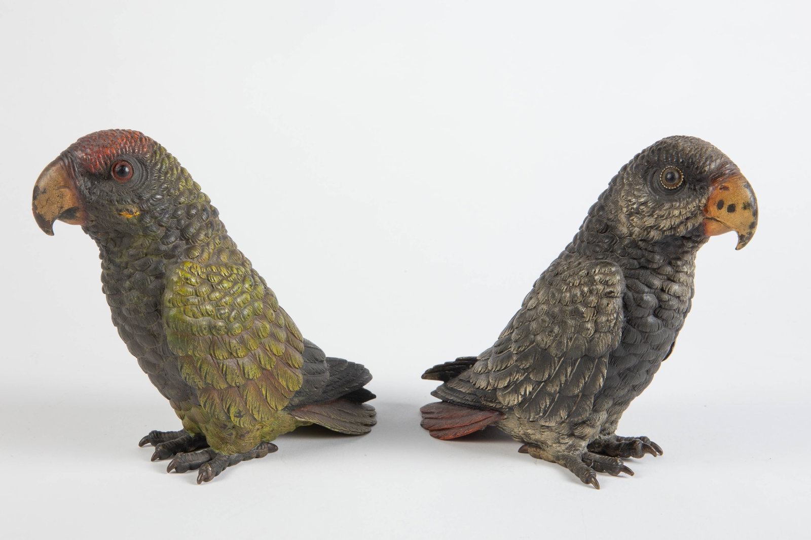 Pair of Vienna Cold Painted Bronze Parrots.: One has brighter colors, the other has more muted tones. Both exhibit some signs of paint loss and surface wear, but overall, they present well. Each one measures 6 3/4" x 3" x 6 1/4". In-house