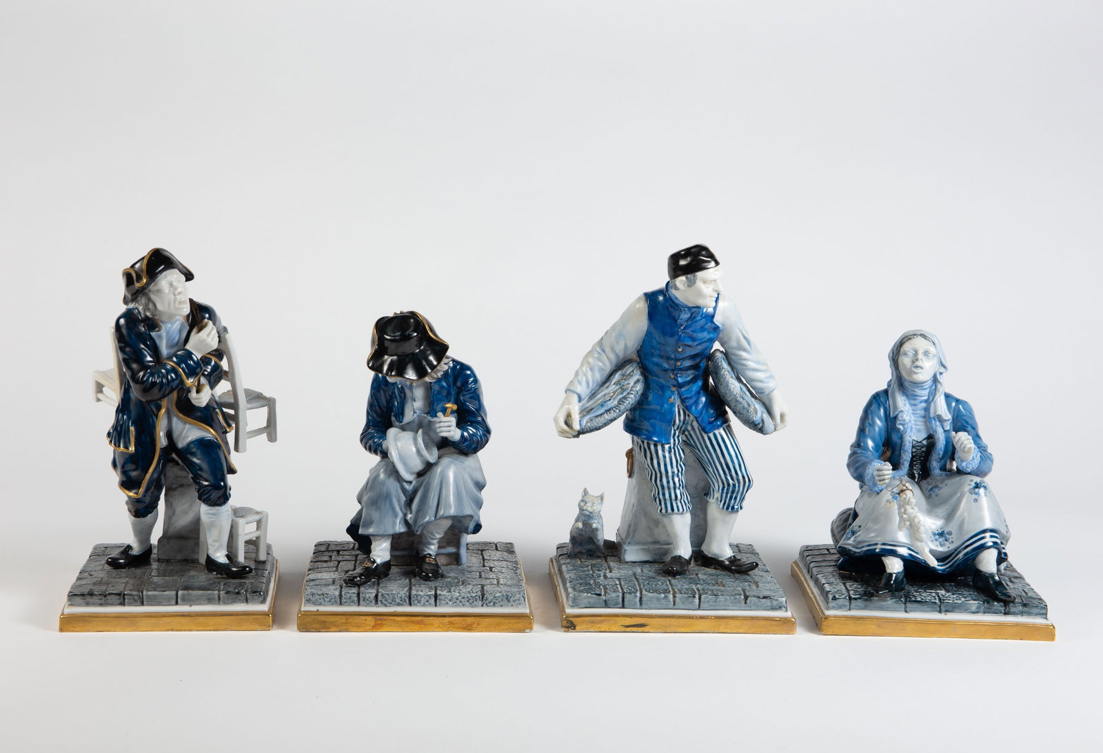 Lot of 4 L. Fabris Painted Figurines.: They are monochromatic figurines with hues of blue, signed underneath. One of the figurines has damage to the back of his chair. The largest figure measures 5 1/2" x 6 3/8" x 10". The smallest figure