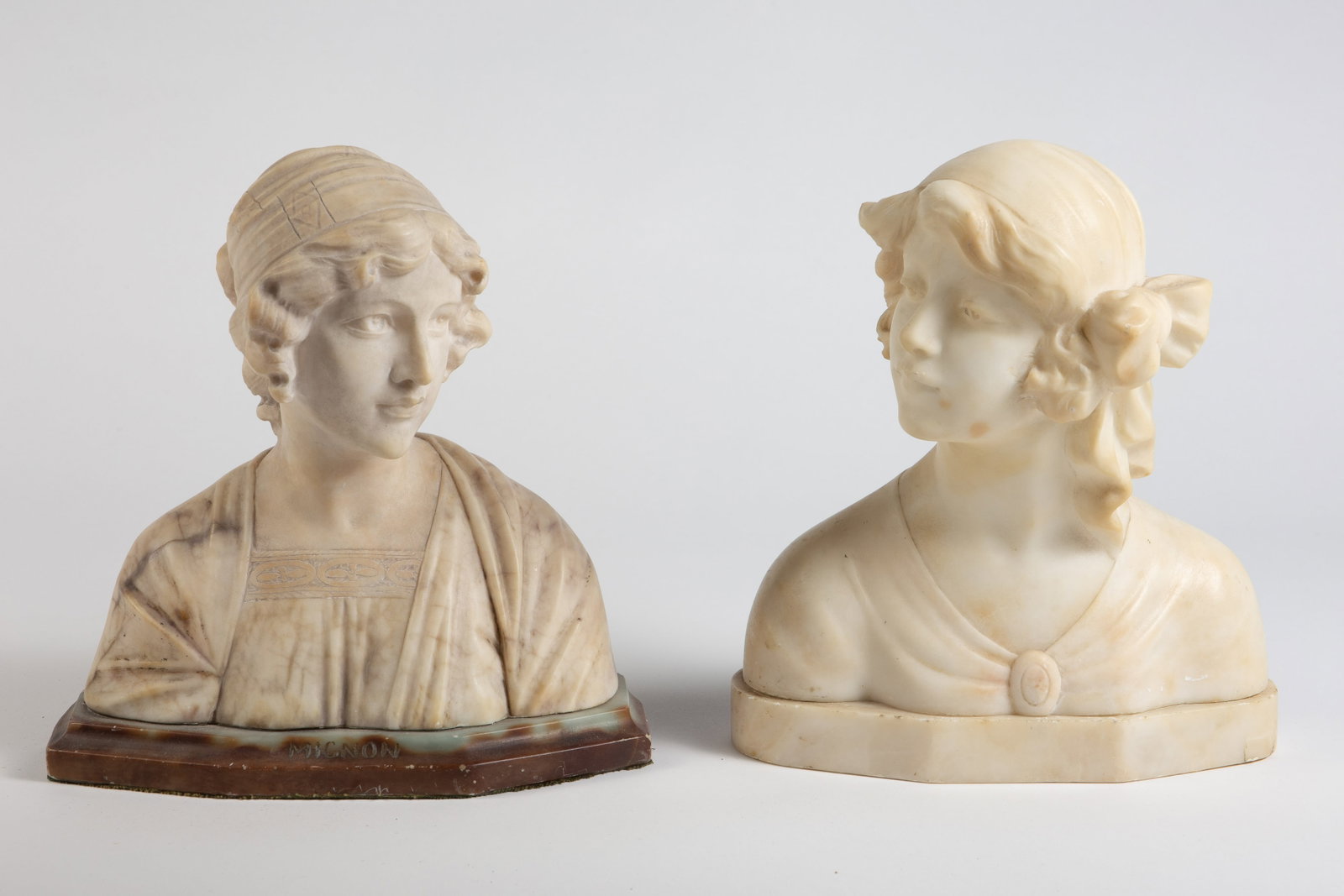 Lot of 2 Italian Marble and Alabaster Female Busts: One is marked, "Liliana" on the back. It measures 8 5/8" x 3 7/8" x 10 1/8". Her hair is chipped, and there are several nicks and scratches present throughout. The other is signed on the back, though