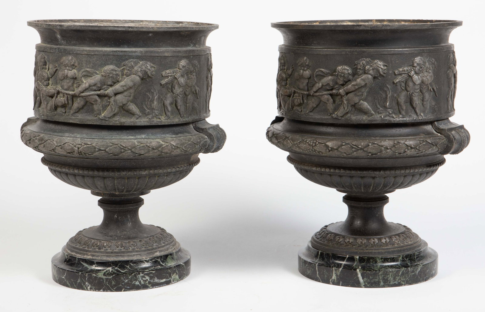 Louis XVI Style Cast Metal & Marble Urn Planters: The planters have black, green, and beige marble bases. The cast metal looks like iron but does not attract a magnet. It has repousse decorations of putty figures. Each piece measures 11 1/2" tall