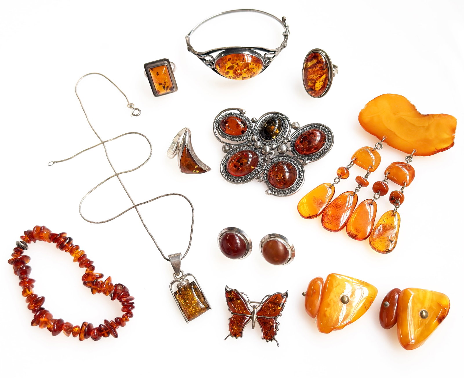 Lot: Amber Jewelry - Butterscotch, Brooches, Cuff.: The lot contains 11 of pieces amber jewelry, most of them set in Sterling Silver. The lot includes butterscotch amber, Baltic amber, and likely other types. There is a cuff bracelet, a beaded