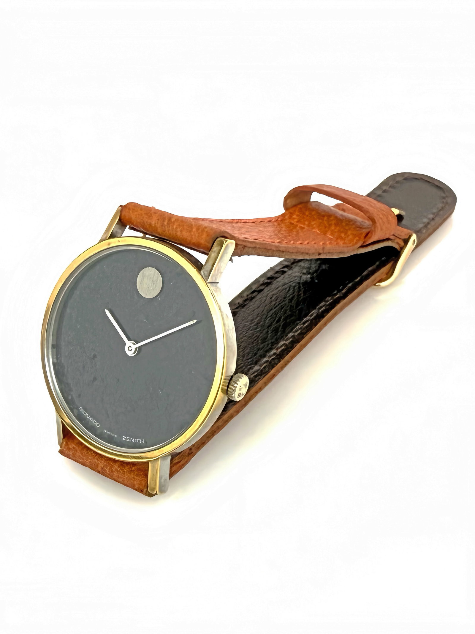 Vintage Movado Zenith Museum Watch: The watch has a gold electroplated bezel, a black dial, and a brown leather band. The face measures 31mm in diameter. It ticks. There is some craquelure on the black face finish, most of the gold