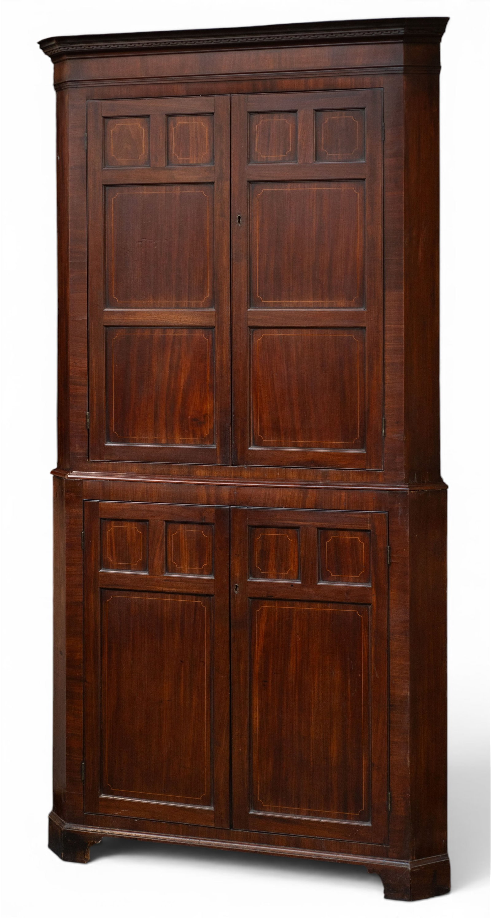 Antique Paneled Corner Cabinet.: This large corner cabinet has an upper and lower section, each with a pair of panelled lockable doors that open onto a storage area. The upper storage area has three fixed shelves, while the lower