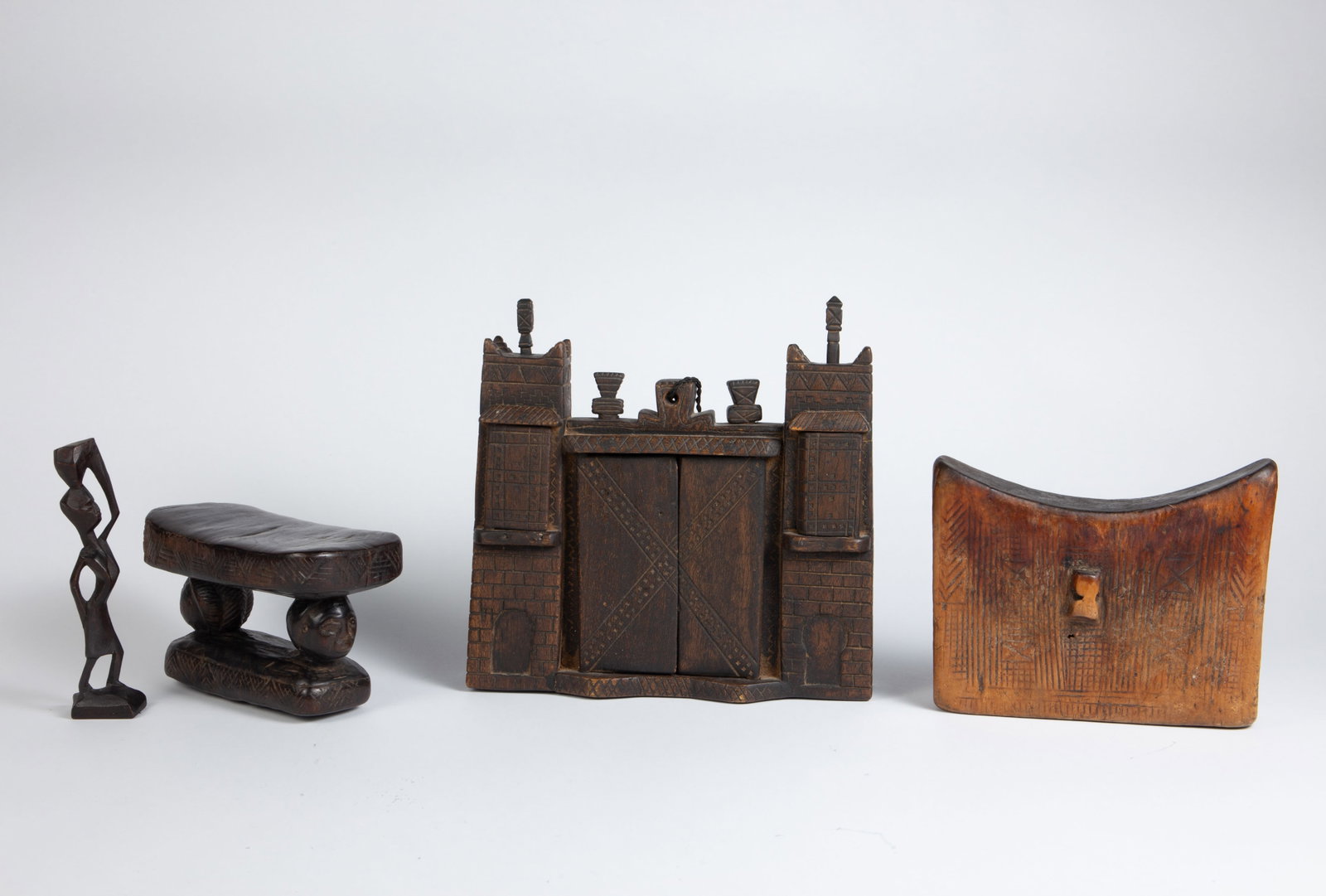 Mostly African Carved Wood Items inc Luba Headrest: The lot contains 4 carved wood items. There is a castle or fortress-shaped wall hanging piece with mirrors behind the two doors and side windows (likely from North Africa or Morocco). Next, there is a