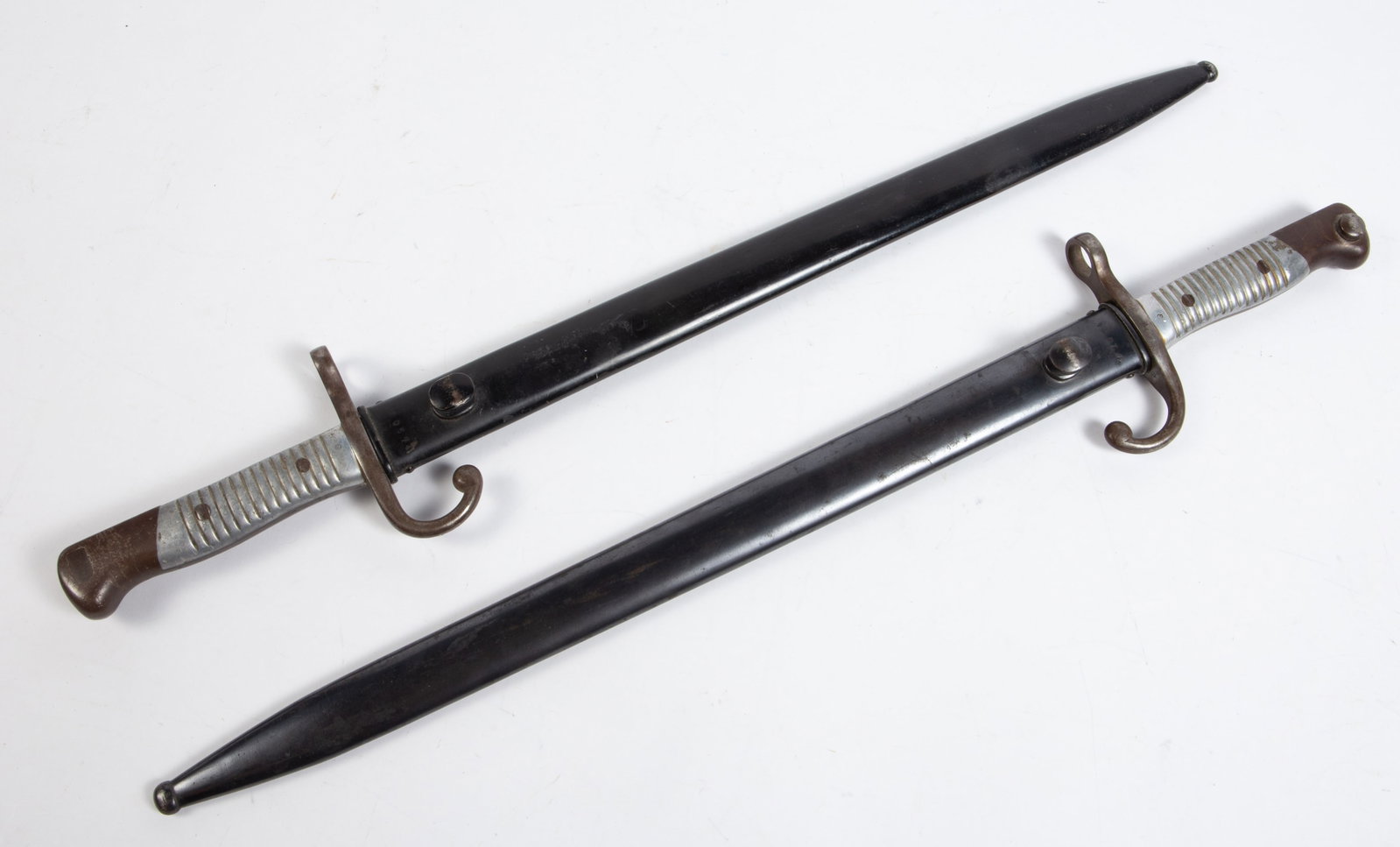 Pair of Weyersberg Kirschbaum & Co. Bayonets.: They read, "Modelo Argentino 1891". One is numbered M 0574, and measures 3 5/8" x 23 1/2" x 1 1/4". The other is numbered M 1534, and measures 3 7/8" x 21 1/8" x 1 1/4". In-house shipping is available