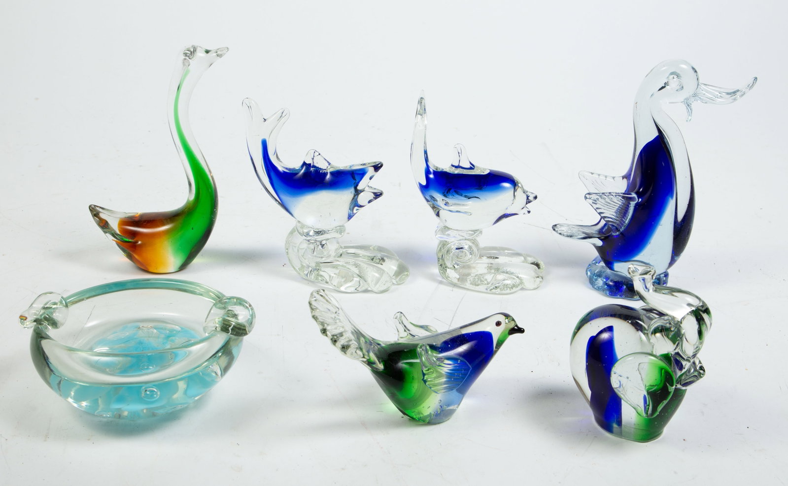 Lot of Murano Style Art Glass Pcs., Mostly Animals: The lot includes a swan, a duck, an elephant, a pair of fish, a bird with outstretched wings, and an ashtray. Overall, it looks to be in good condition. The largest item measures 5" x 2 3/8" x 6 7/8".