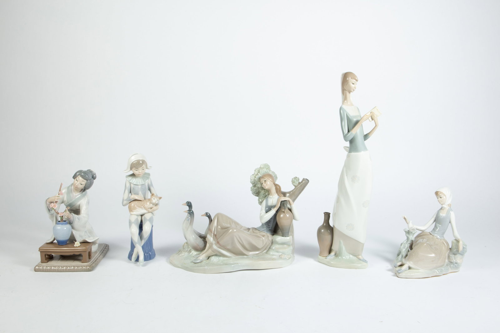 Lot of 5 Lladro Figurines - Women & Boy.: The smallest figurine is the Nao Harlequin boy petting his cat. It measures 3 3/8" x 3 3/4" x 9". The largest figurine measures 3 1/4" x 4 1/2" x 15 3/4". This figurine is missing a thumb. The other f