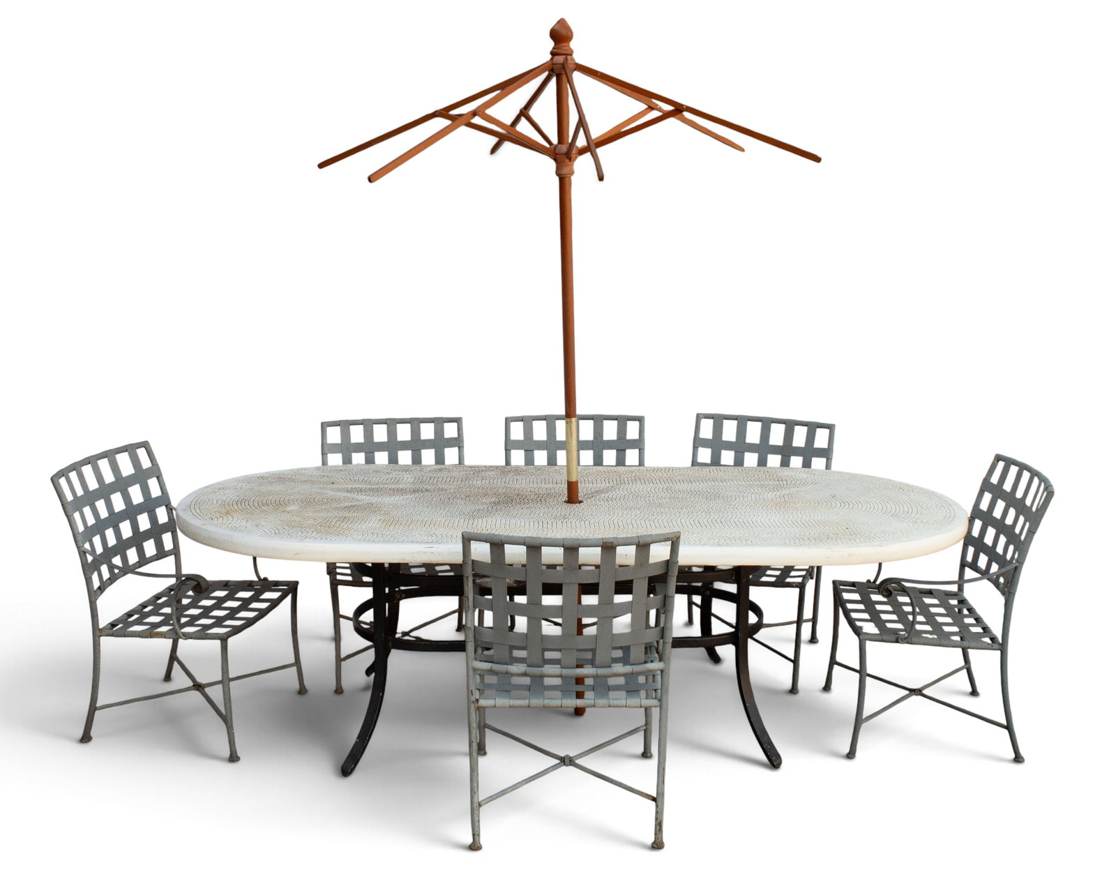 Smith & Hawken Patio Dining Set.: This set includes an outdoor dining table, six chairs, and an umbrella. The table is oval with a tessellated top. The metal chairs have a woven style. The pieces have some light rust, and the tabletop