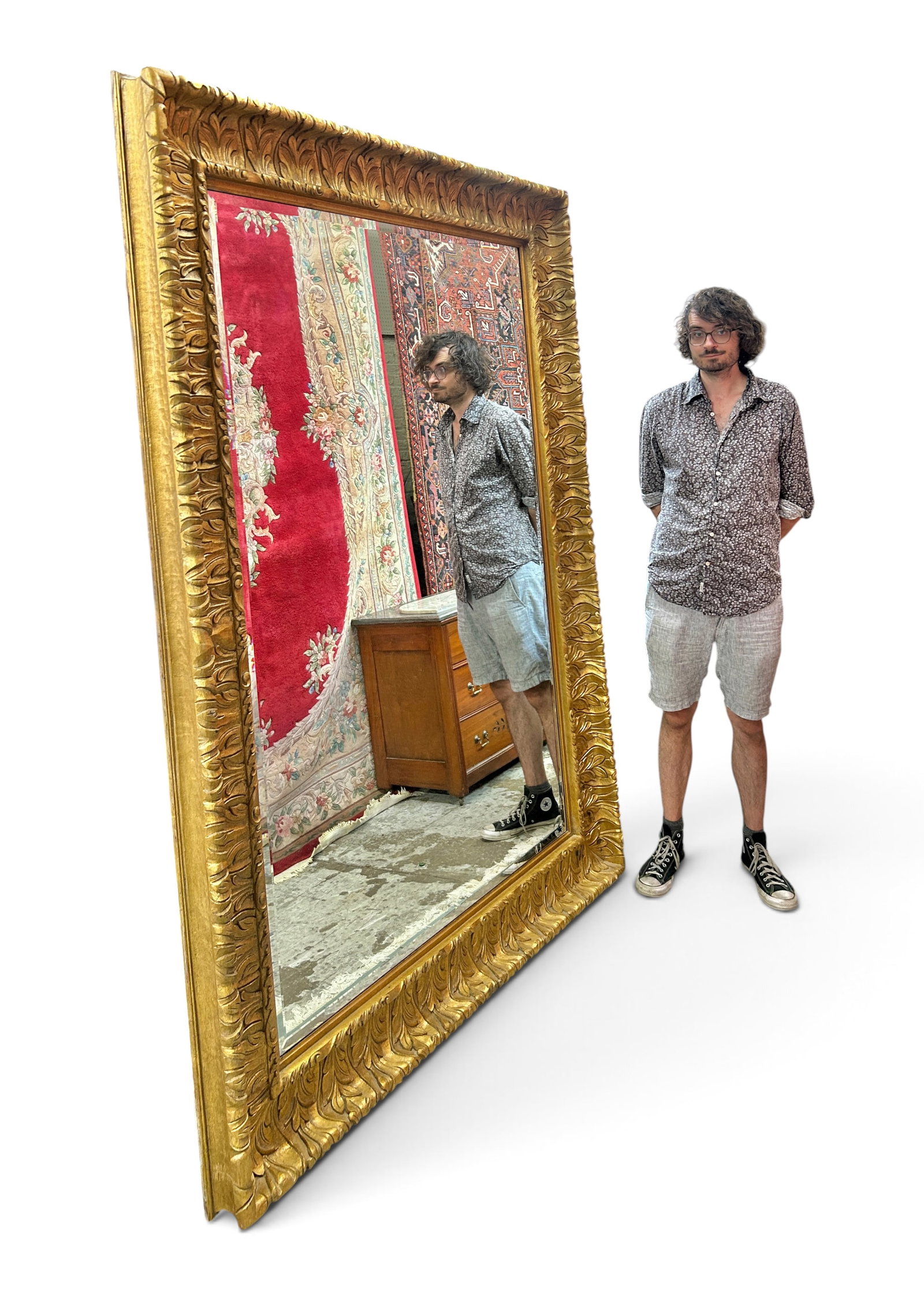 Monumental Beveled Mirror w/ Carved Gilt Frame, 7': The mirror has a nearly 7 1/2" tall carved wood frame with a gilded finish. It features a foliage and scroll pattern. The mirror measures 88" tall, 63" wide, and 4 1/2" deep. There are a few cracks on