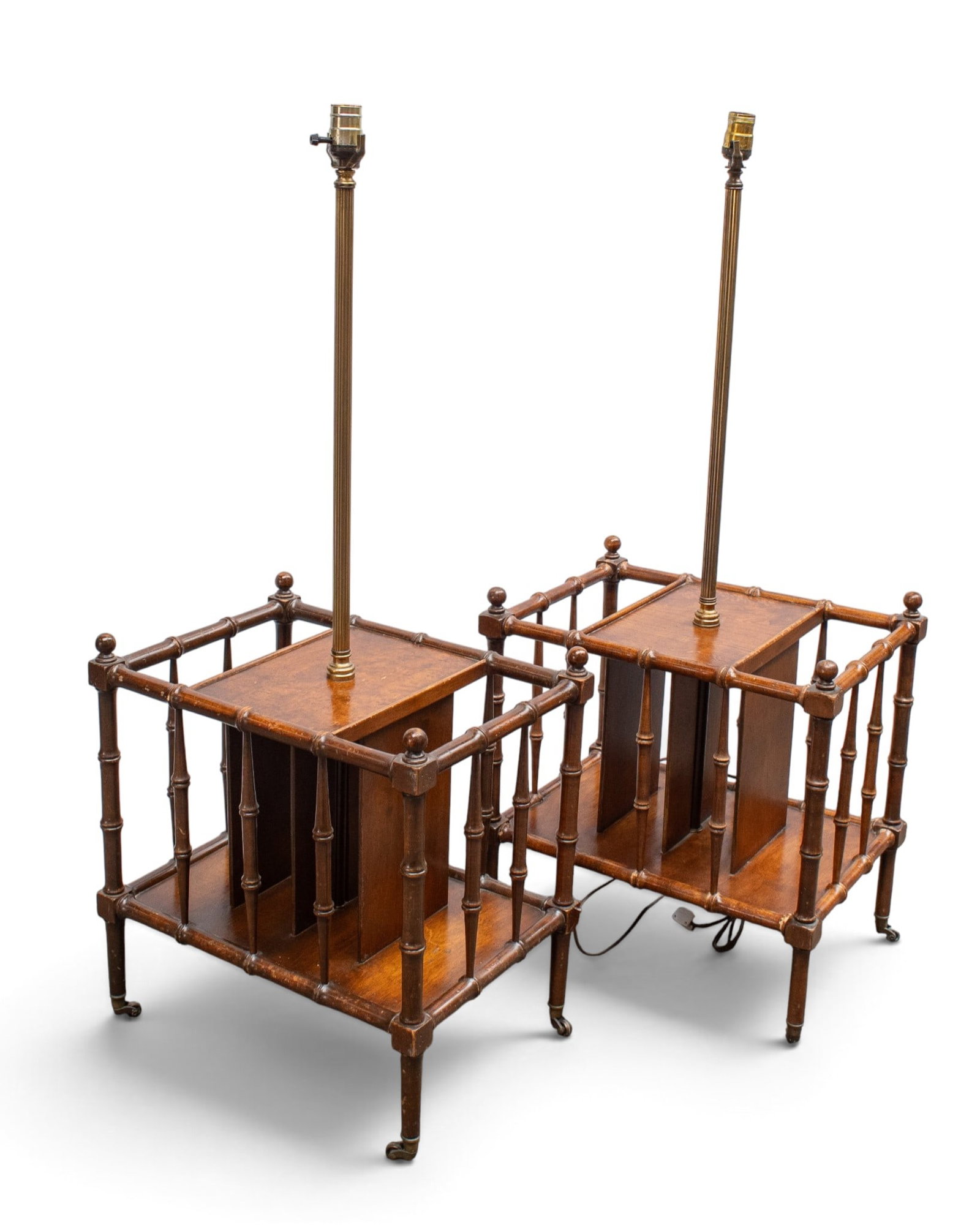 2 Frederick Cooper Faux Bamboo Magazine Rack Lamps: The pair of Canterbury magazine rack floor lamps are attributed to Frederick Cooper. The racks have 4 sections, 2 of them being accessible only from the sides, and casters on the feet. The pieces
