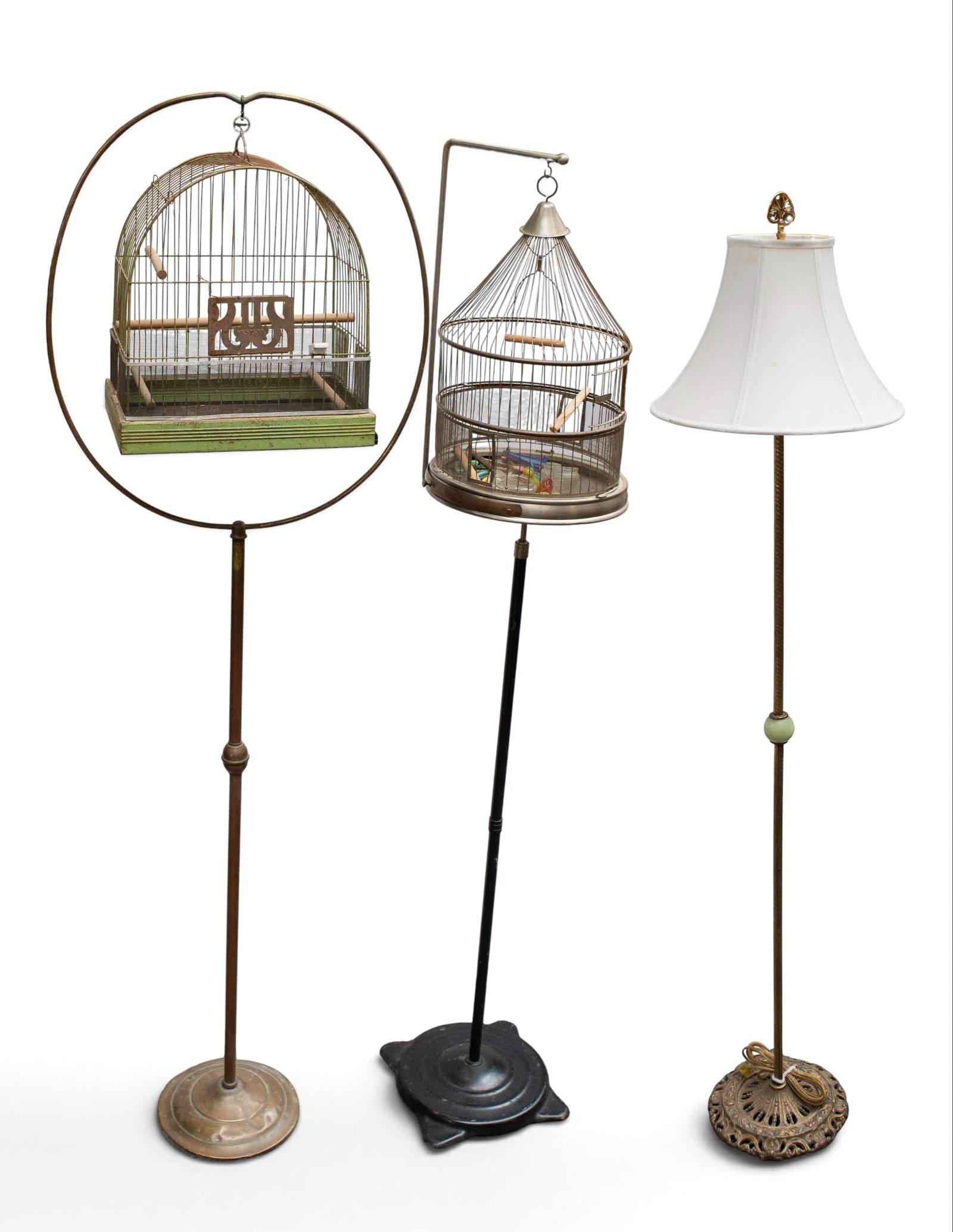 2 Antique Bird Cages & Lamp - Hendryx, Lindemann.: The lot contains 2 birdcages with floor stands, and a floor lamp. The tallest cage is branded Hendryx, and features a green painted metal arched cage hanging with a circular setting, which is held by