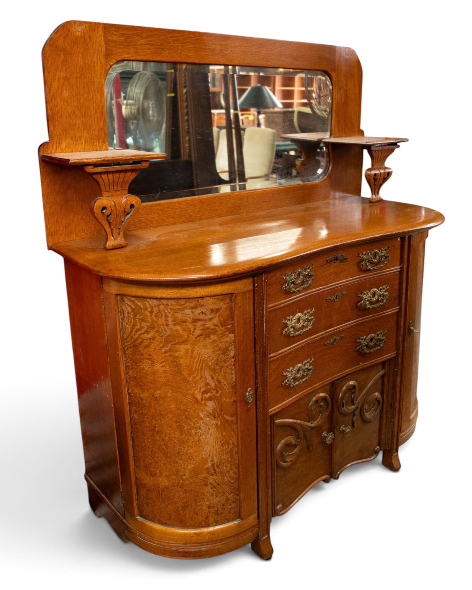 Ornate Antique Oak Sideboard or Buffet.: The piece, which sits on casters, can be separated into 2 pieces for transport. The top section has a beveled mirror with curved corners and two bracket shelves. The bottom section has three central