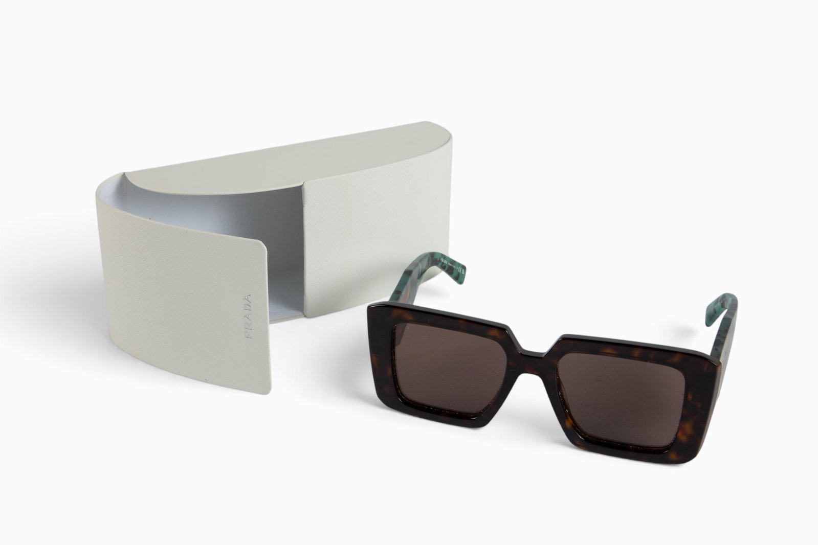 Pair of Prada Symbole Sunglasses.: The Italian made designer sunglasses are from spring 2023. They are model PR 23YS 2AU-06B. The brown frames measure 2 1/8" x 5 5/8", and the temples measure 5 3/8" x 1 1/16". The glasses are adjusted