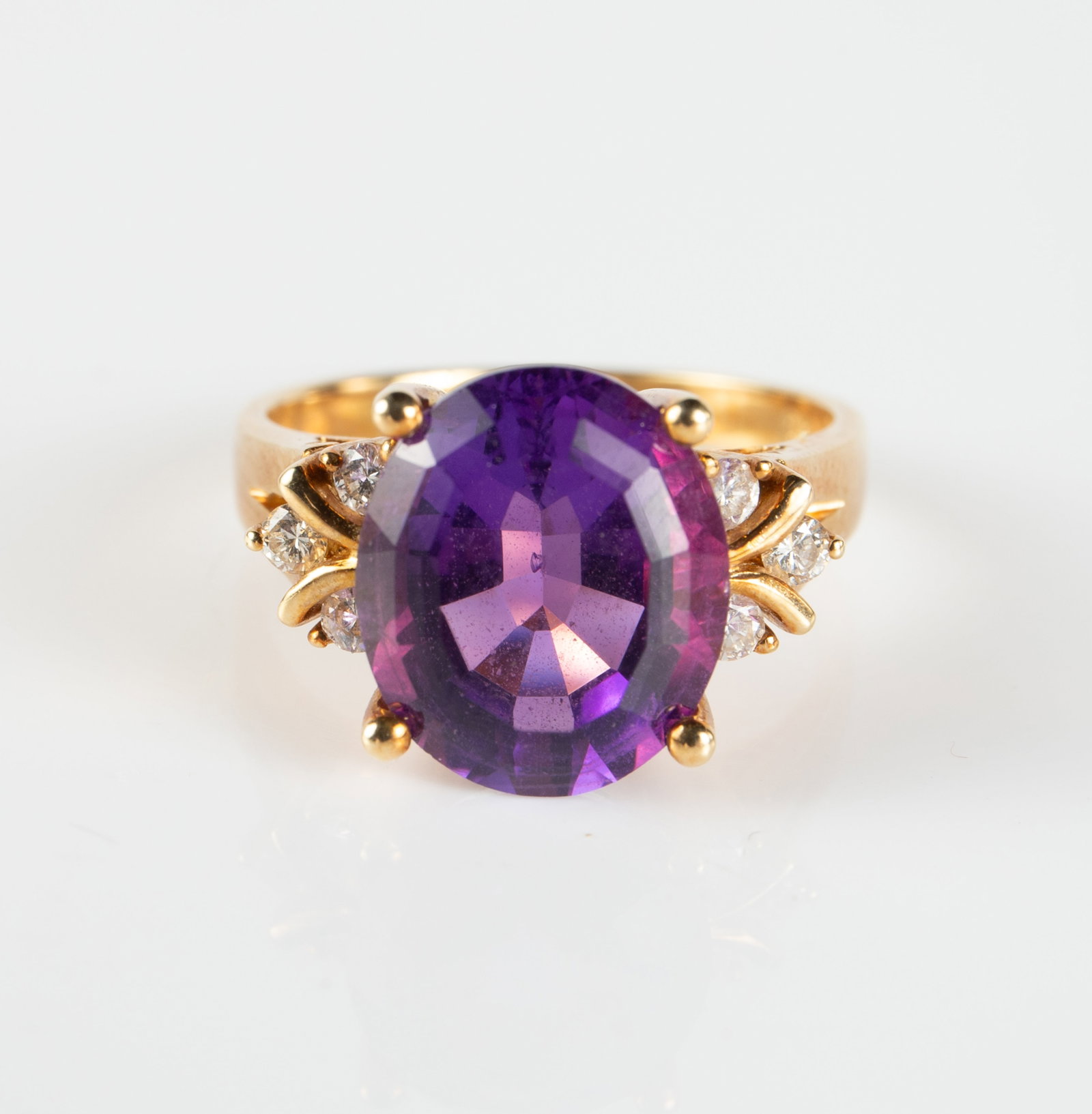 14K Gold, Amethyst & Diamond Ring.: The ring is marked 14K inside the band. It features an oval cut purple amethyst, flanked by 3 round diamonds on each side. The amethyst measures 12mm x 10mm, weighing roughly between 4-5 Carats. The