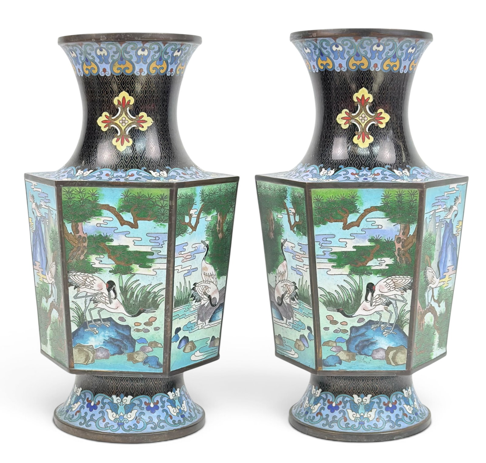 Pair of 20th Century Chinese Cloisonne Vases.: This pair is very ornate and detailed, in a hexagonal form. They feature a landscape scene with cranes. The pair is in good overall condition. Each vase measures 12 1/4" tall and 5 3/4" in diameter.