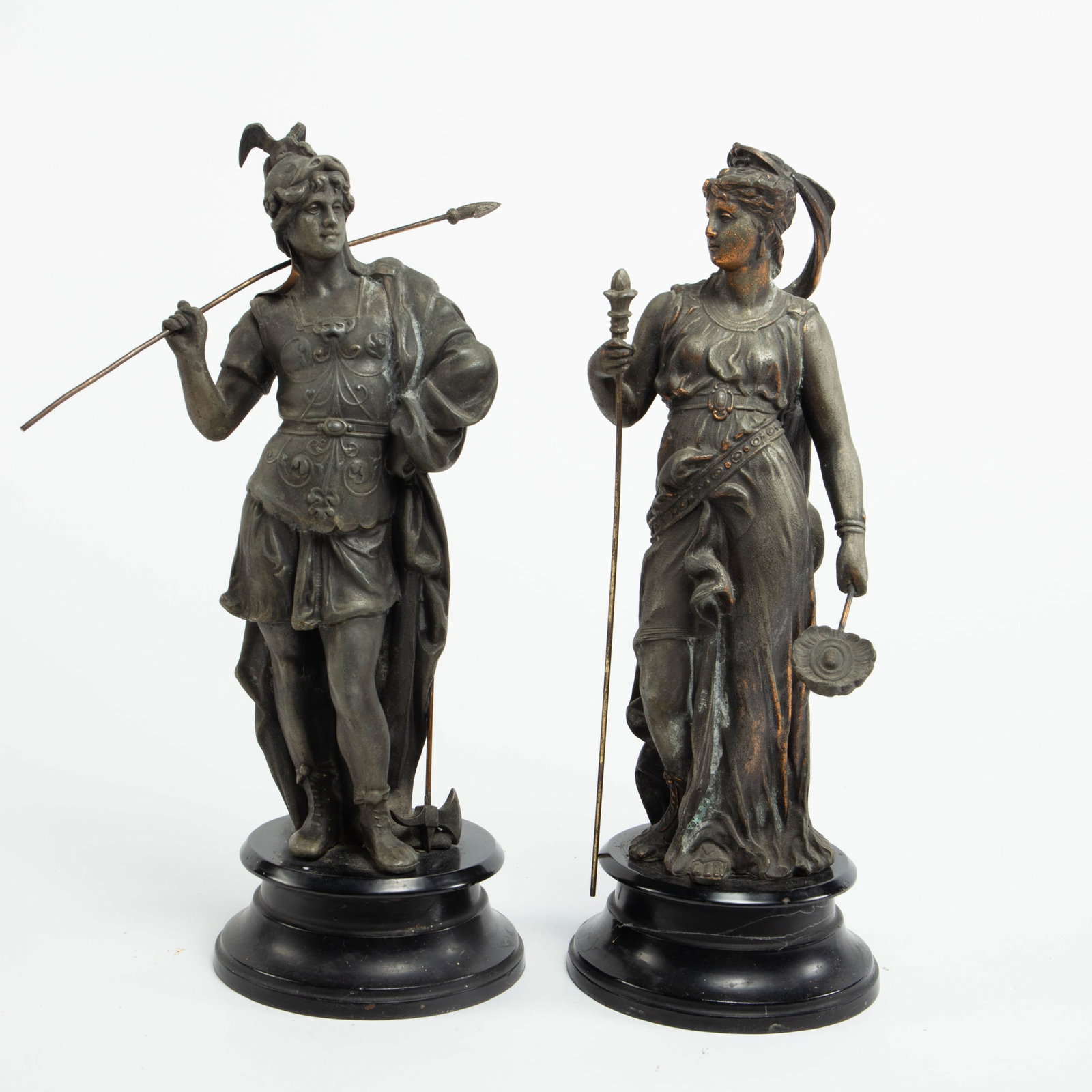 Spelter Grecian Style Male & Female Sculptures.: One is a warrior with a spear, the other is a woman with a staff (she is a bit loose on her base). They could use a little cleaning, and his spear is bent. She measures 5" x 5" x 13 7/8"; he measures