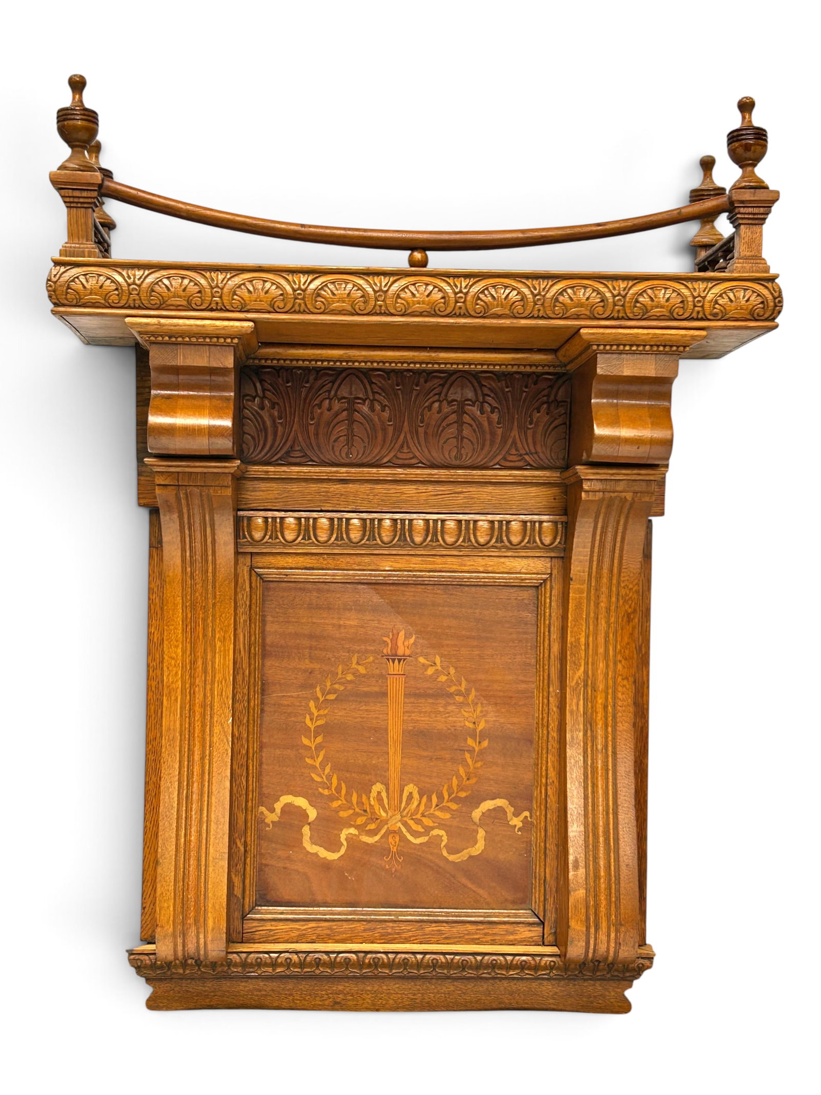 Antique Carved Wall Shelf w/ Marquetry.: The item has a mantel-style shelf at the top with a gallery rail and turned wood finials. Under the shelf there is a carved panel, followed by a wood inlaid section depicting a torch inside a wreath w